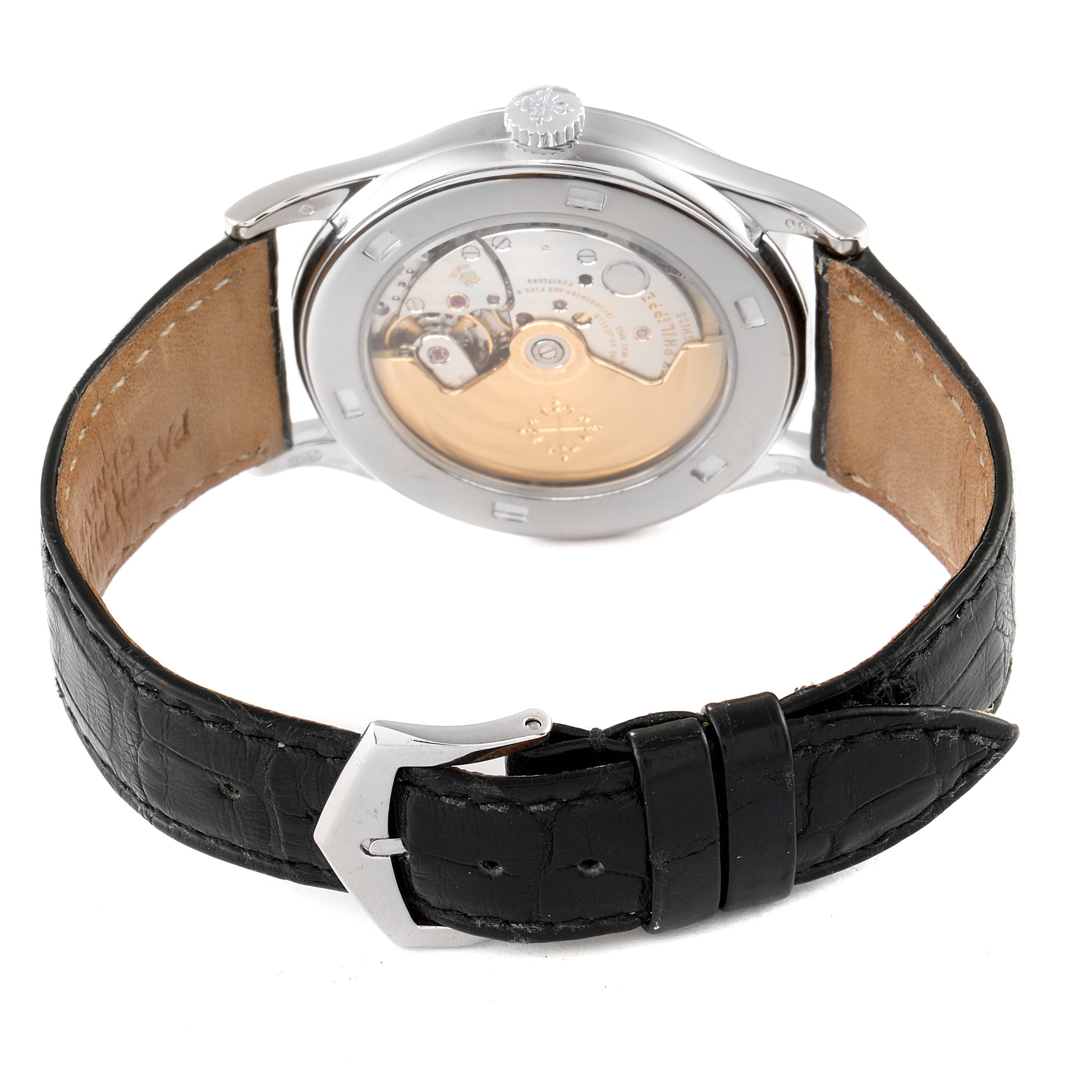 The image shows the back view of a Patek Philippe Calatrava 5296G Men's White Gold Silver Dial 5296G Men's White Gold Silver Dial watch, revealing its movement and leather strap with a buckle.