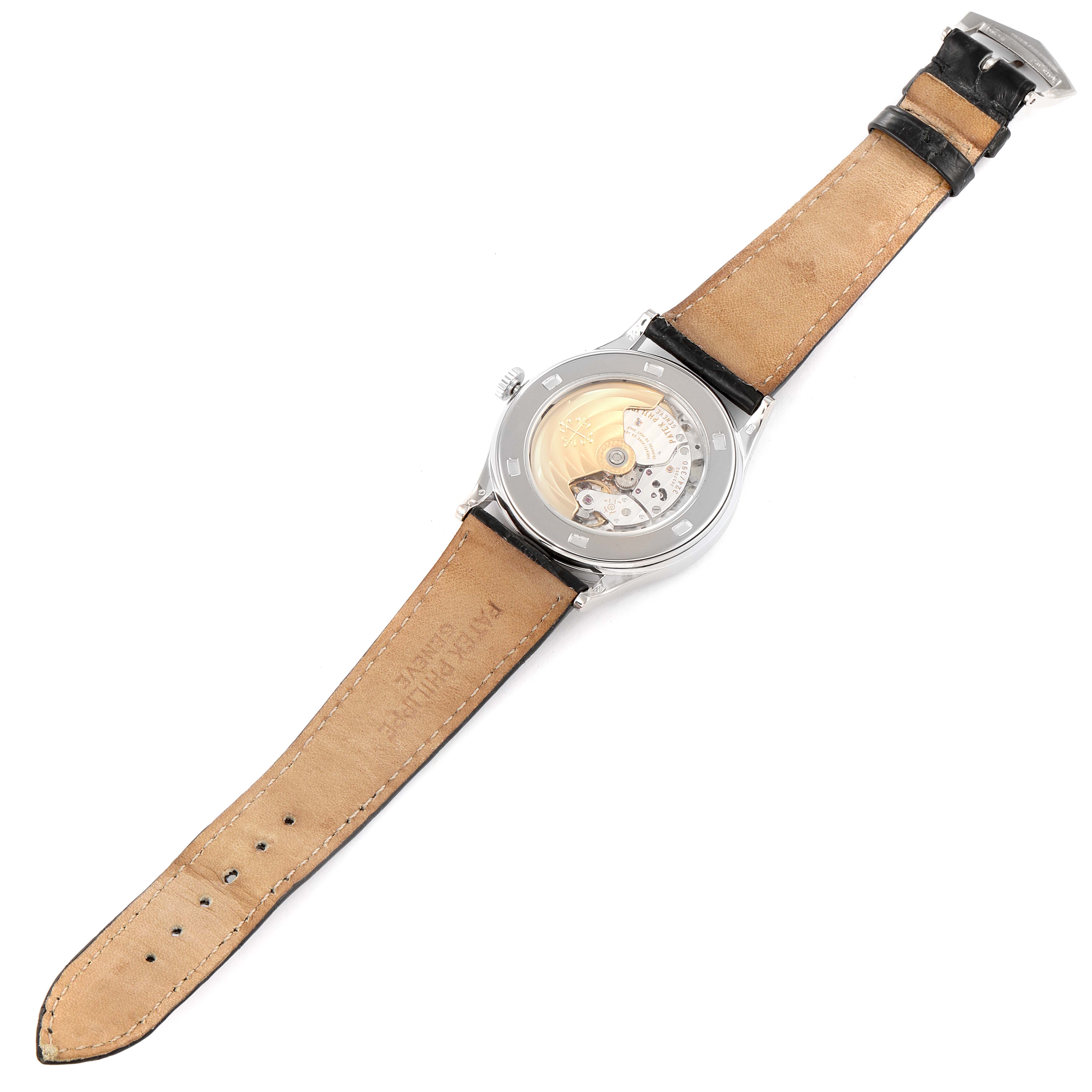 The image shows a rear view of the Calatrava model by Patek Philippe, highlighting its exposed movement and leather straps.