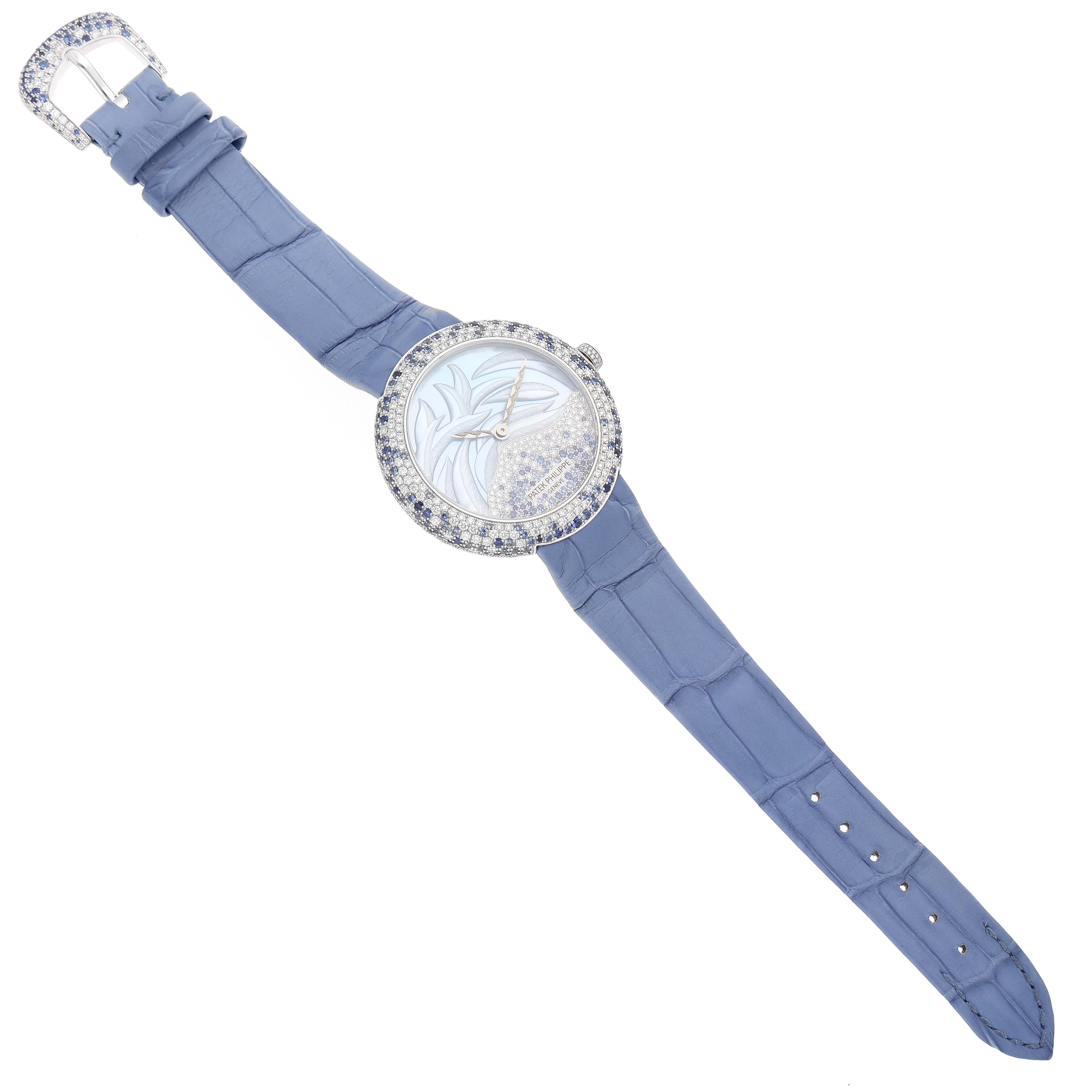 The image shows a top-view angle of a Patek Philippe Calatrava 4899/901G Women's White Gold Mother of Pearl Dial 4899/901G Women's White Gold Mother of Pearl Dial watch with a blue leather strap and a diamond-studded bezel.