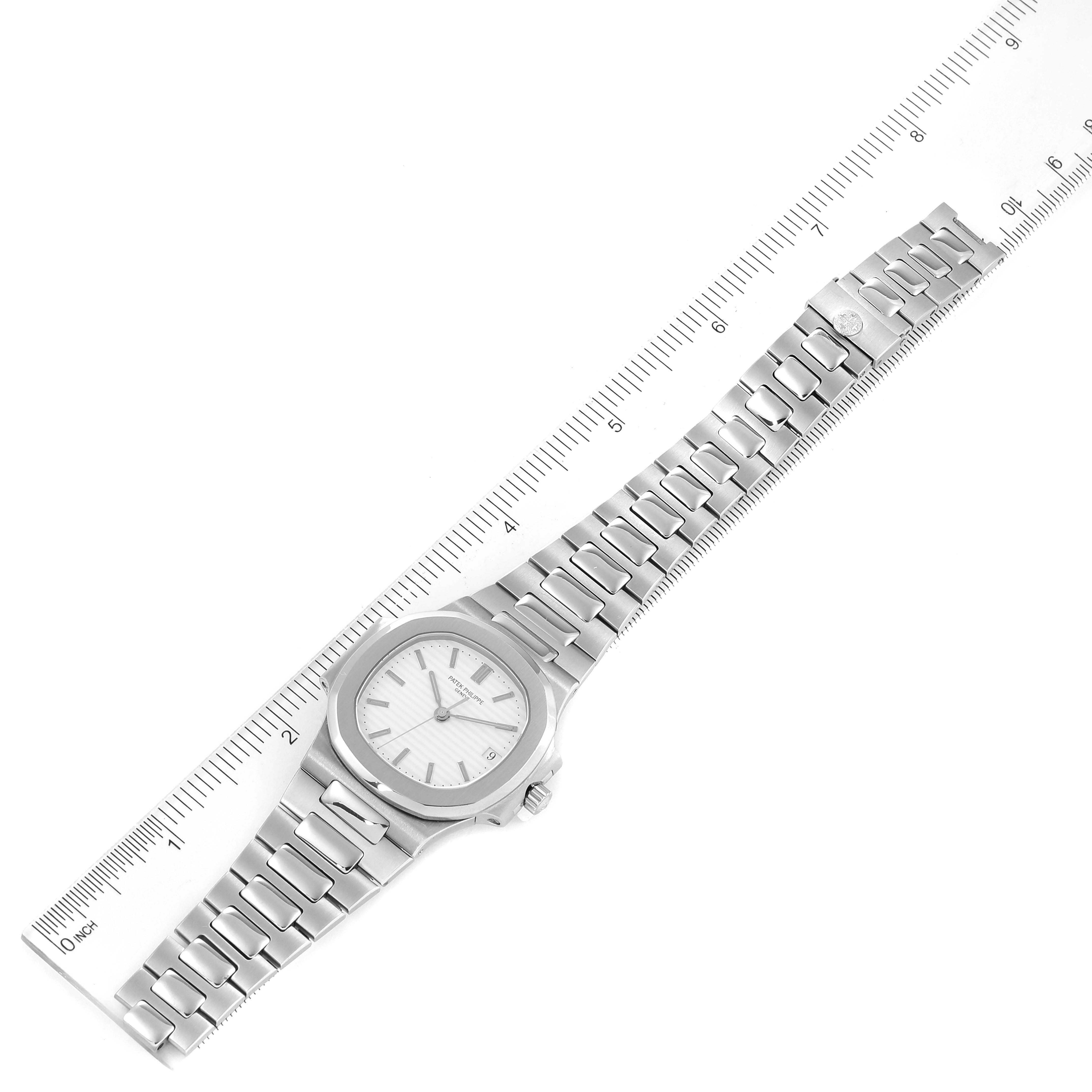 The image shows a top-down view of a Patek Philippe Nautilus 3800/1 Men's Stainless Steel White Dial 3800/1 Men's Stainless Steel White Dial watch with its stainless steel band extended alongside a ruler.