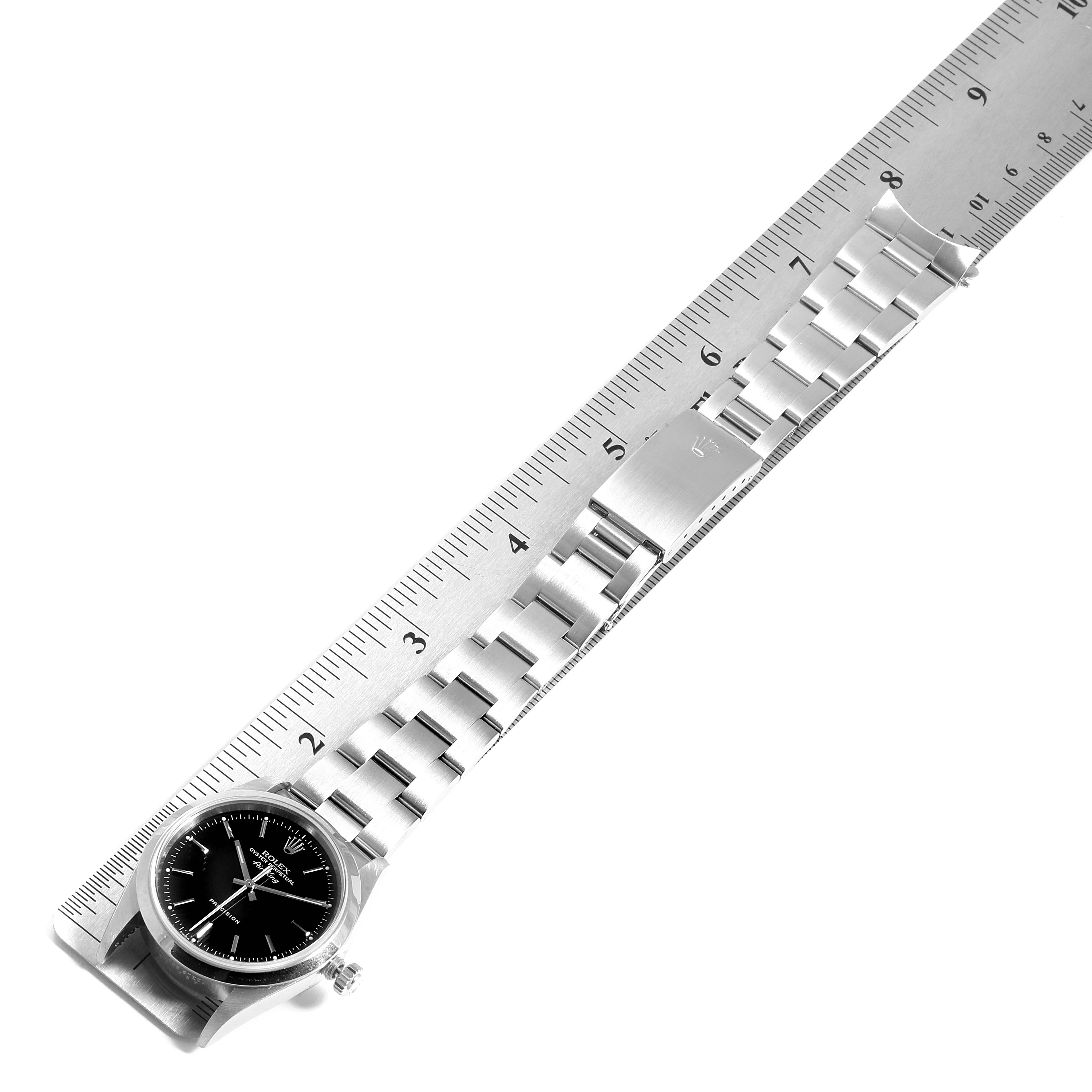 The image shows a Rolex Air-King 14000  Men's Stainless Steel Black Dial 14000  Men's Stainless Steel Black Dial watch laid flat with a ruler, displaying the entire band and watch face at an angled top view.