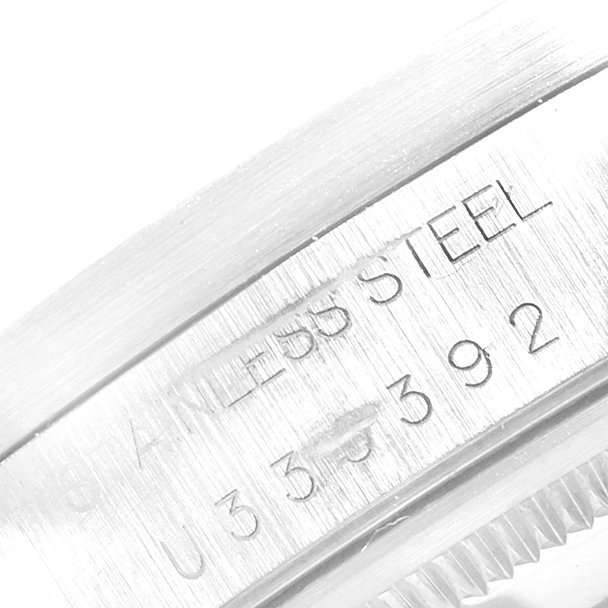This close-up image shows the stainless steel casing and part of the serial number of the Rolex Air-King 14010 Men's Stainless Steel Black Dial 14010 Men's Stainless Steel Black Dial watch.