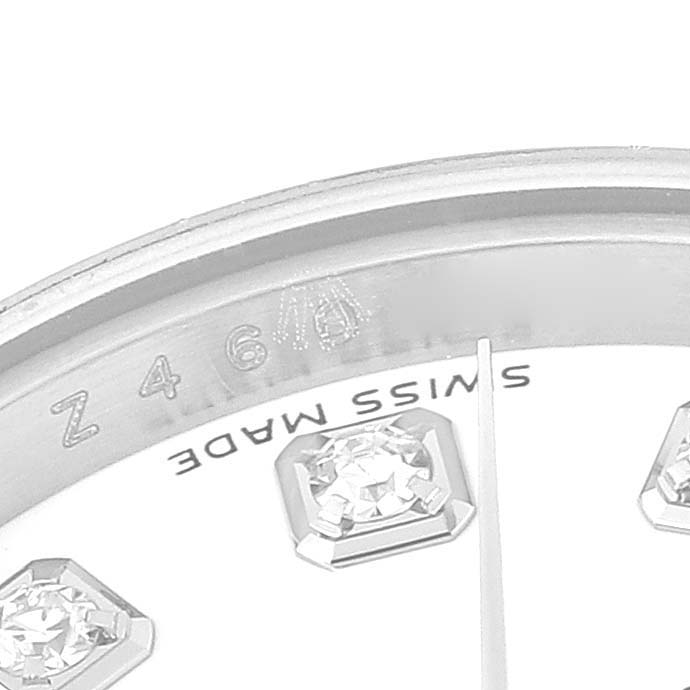 This close-up image of the Rolex Datejust M179174 Women's Stainless Steel White Dial M179174 Women's Stainless Steel White Dial watch shows part of the dial, showcasing diamond hour markers and the edge of the bezel.