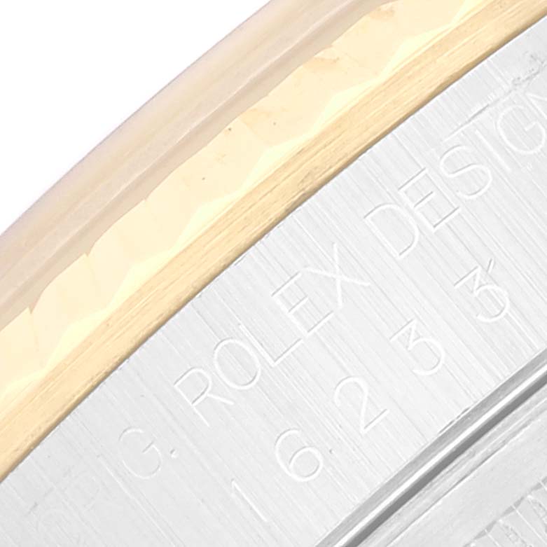 This image shows a close-up of the edge and engraved side of a Rolex Datejust 16233 Men's Steel and Gold (two tone) Silver Dial 16233 Men's Steel and Gold (two tone) Silver Dial watch case.