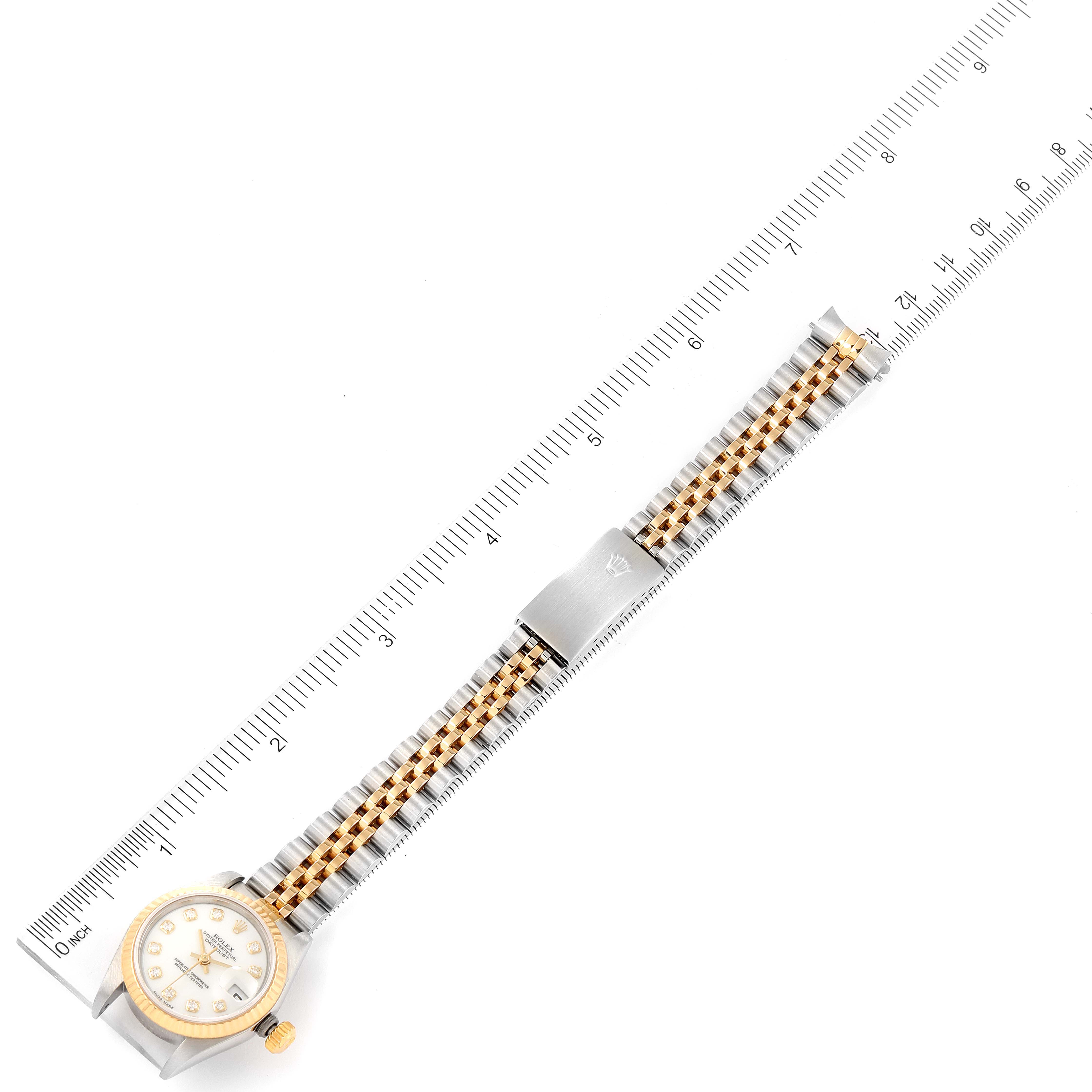 The image shows a Rolex Datejust 69173 Women's Steel and Gold (two tone) White Dial 69173 Women's Steel and Gold (two tone) White Dial watch from a top-down angle, highlighting its face, bezel, and two-tone bracelet beside a ruler.