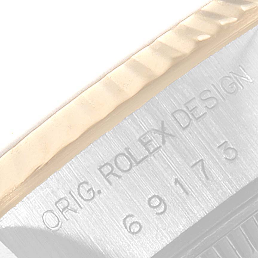 This close-up shows the engraved model number and part of the bezel of a Rolex Datejust 69173 Women's Steel and Gold (two tone) White Dial 69173 Women's Steel and Gold (two tone) White Dial watch.