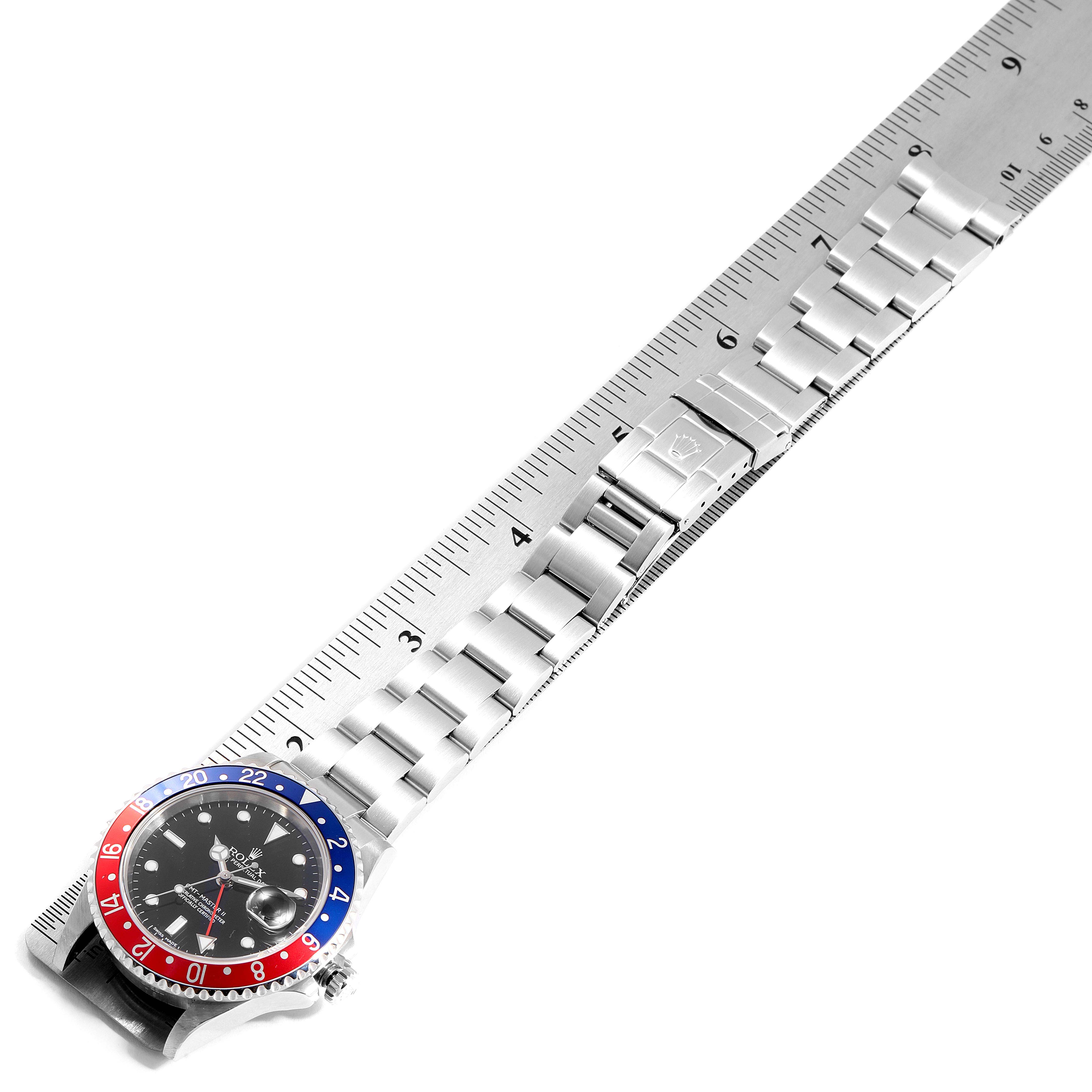 The image shows a top-down view of a Rolex GMT-Master 16710 Men's Stainless Steel Black Dial 16710 Men's Stainless Steel Black Dial watch, highlighting its black dial, red-blue bezel, stainless steel bracelet, and measuring tape.