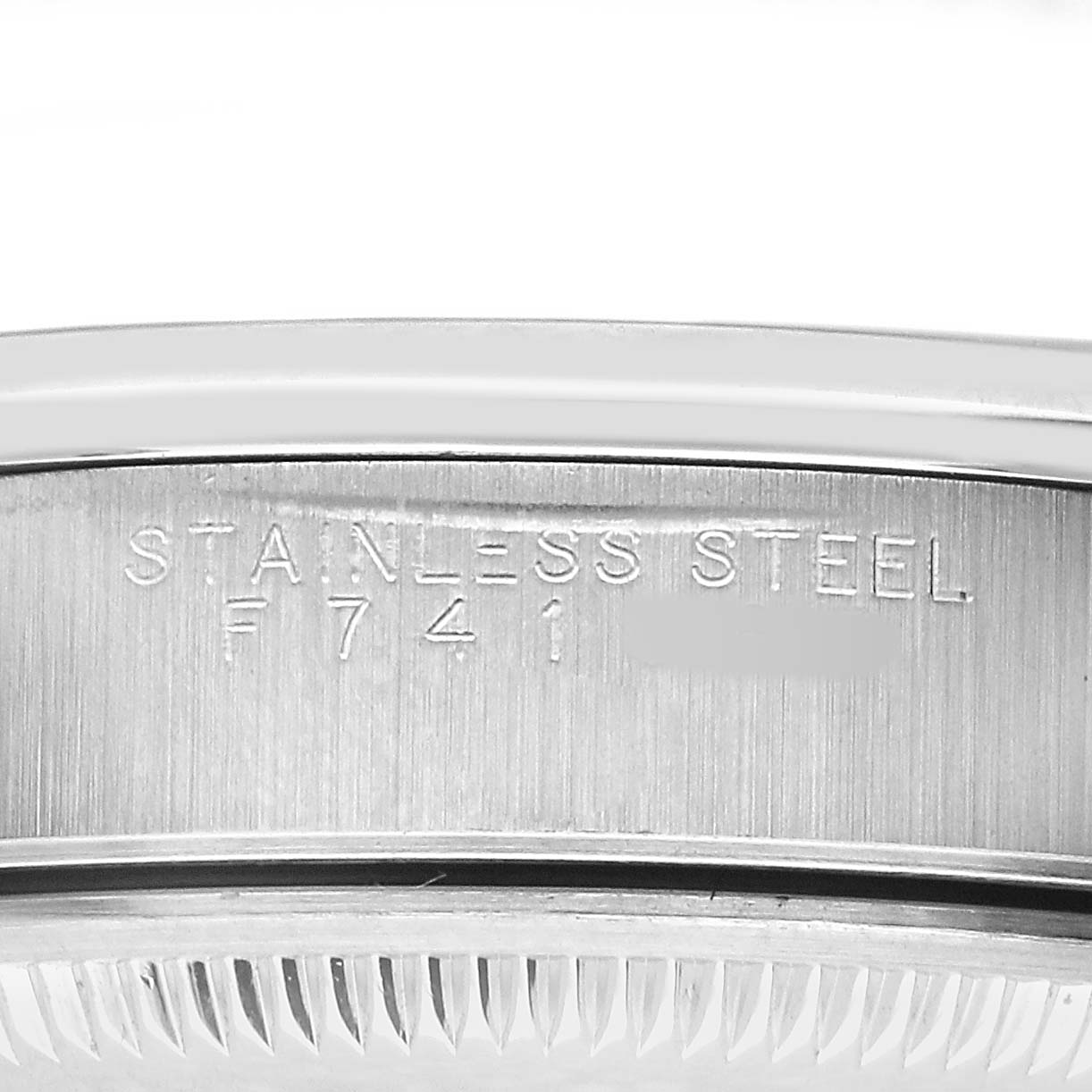The image shows a close-up of the side of a Rolex Date 15200 Men's Stainless Steel Black Dial model watch case, highlighting the "STAINLESS STEEL" engraving.