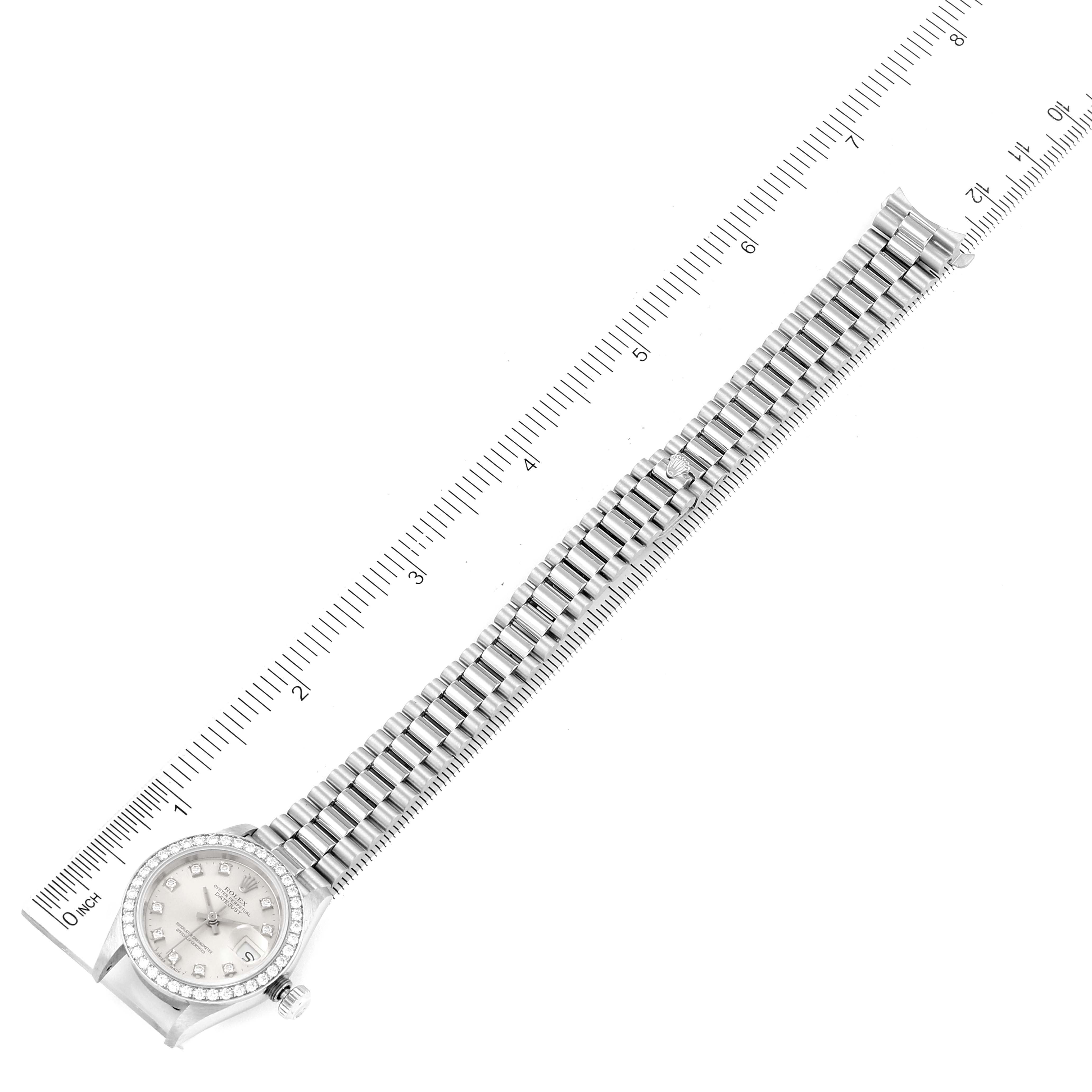 The image shows a top-down view of a Rolex President 69136 Women's Platinum Silver Dial 69136 Women's Platinum Silver Dial model watch, displaying the full bracelet and face beside a ruler.