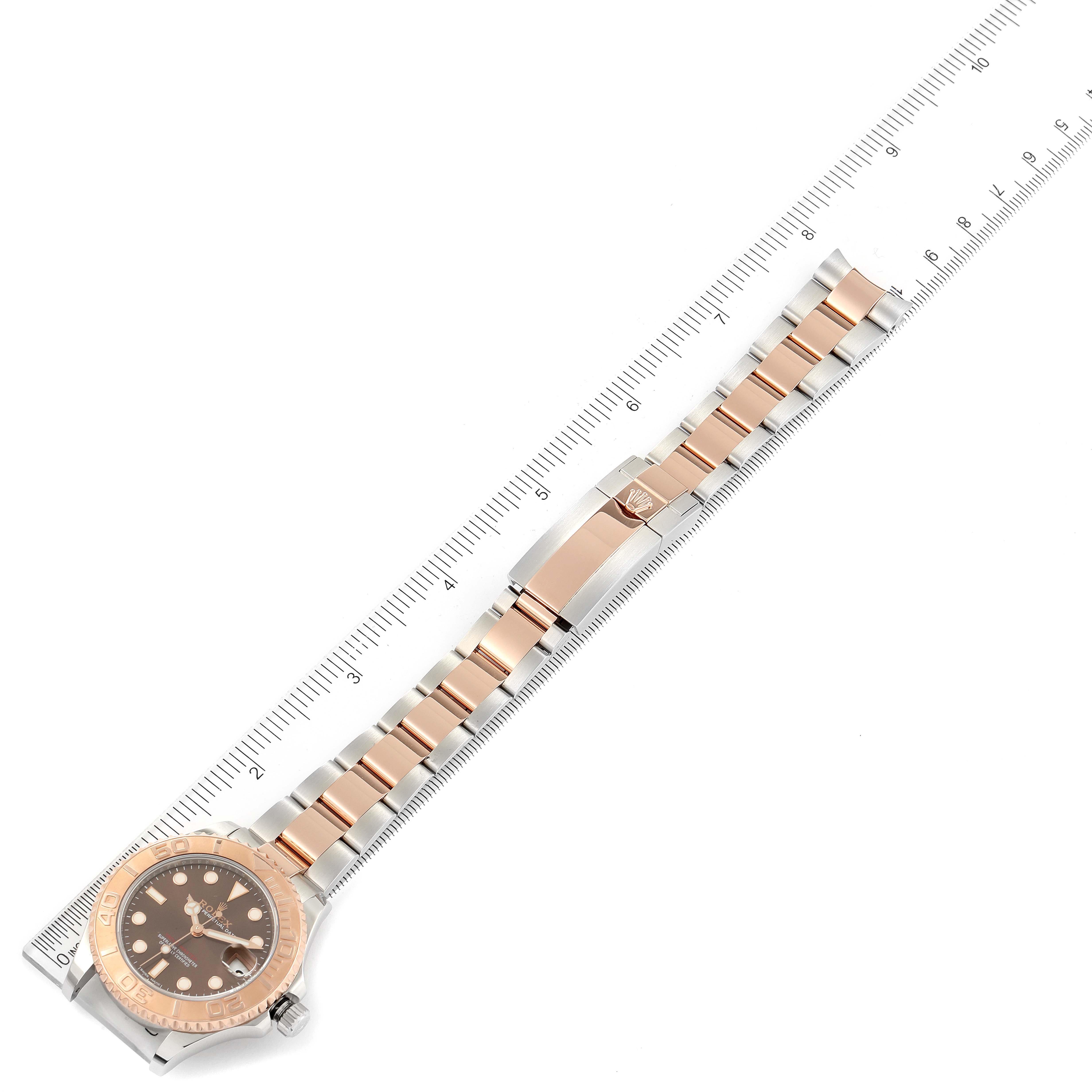 The image shows a Rolex Yacht-Master 268621 Men's Steel and Gold (two tone) Brown Dial 268621 Men's Steel and Gold (two tone) Brown Dial watch placed next to a ruler, displaying the full length of its case, dial, and bracelet.