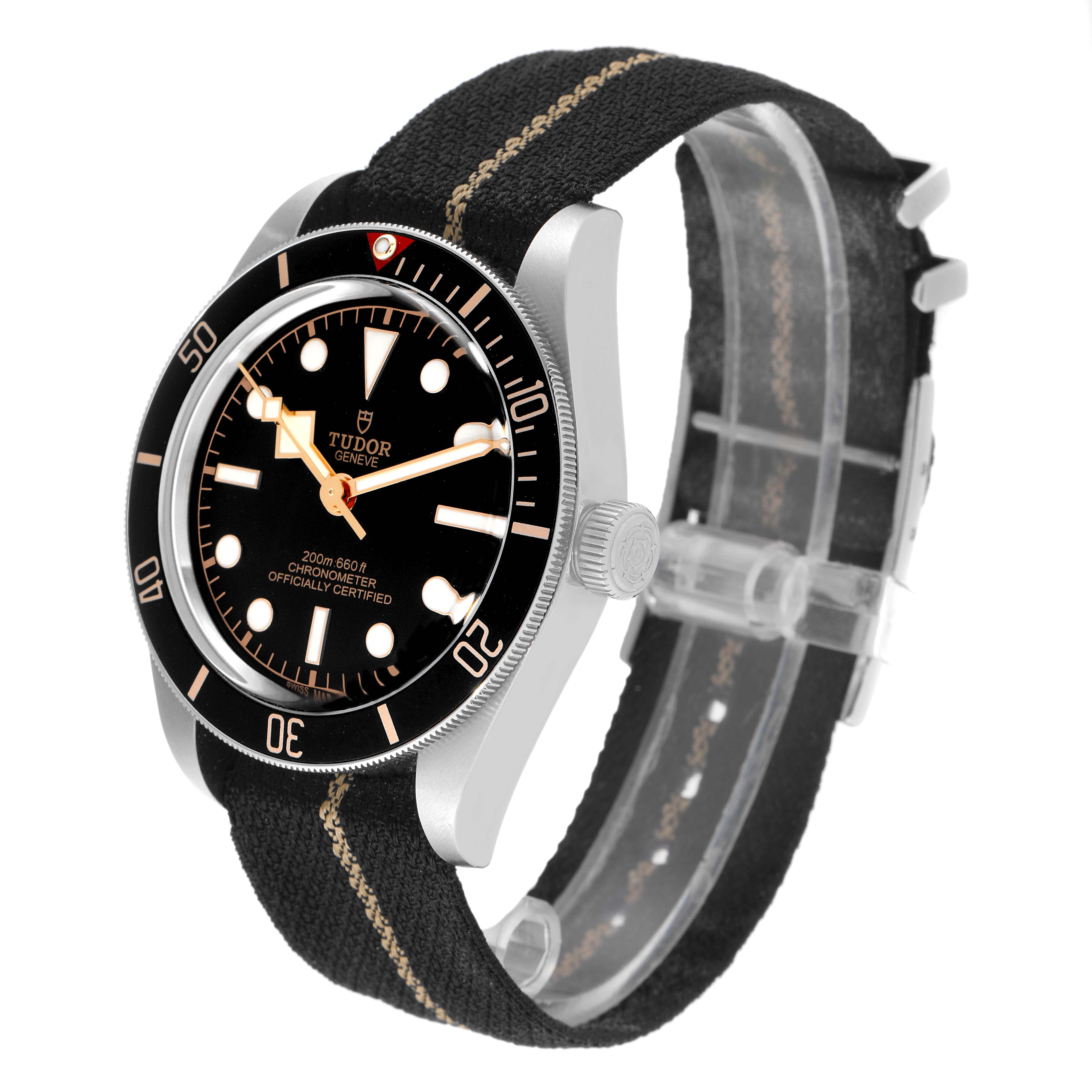 The image shows a Tudor Heritage Black Bay 79030N Men
s Stainless Steel Black Dial 79030N Men
s Stainless Steel Black Dial watch at an angle displaying the face, bezel, crown, and fabric strap.
