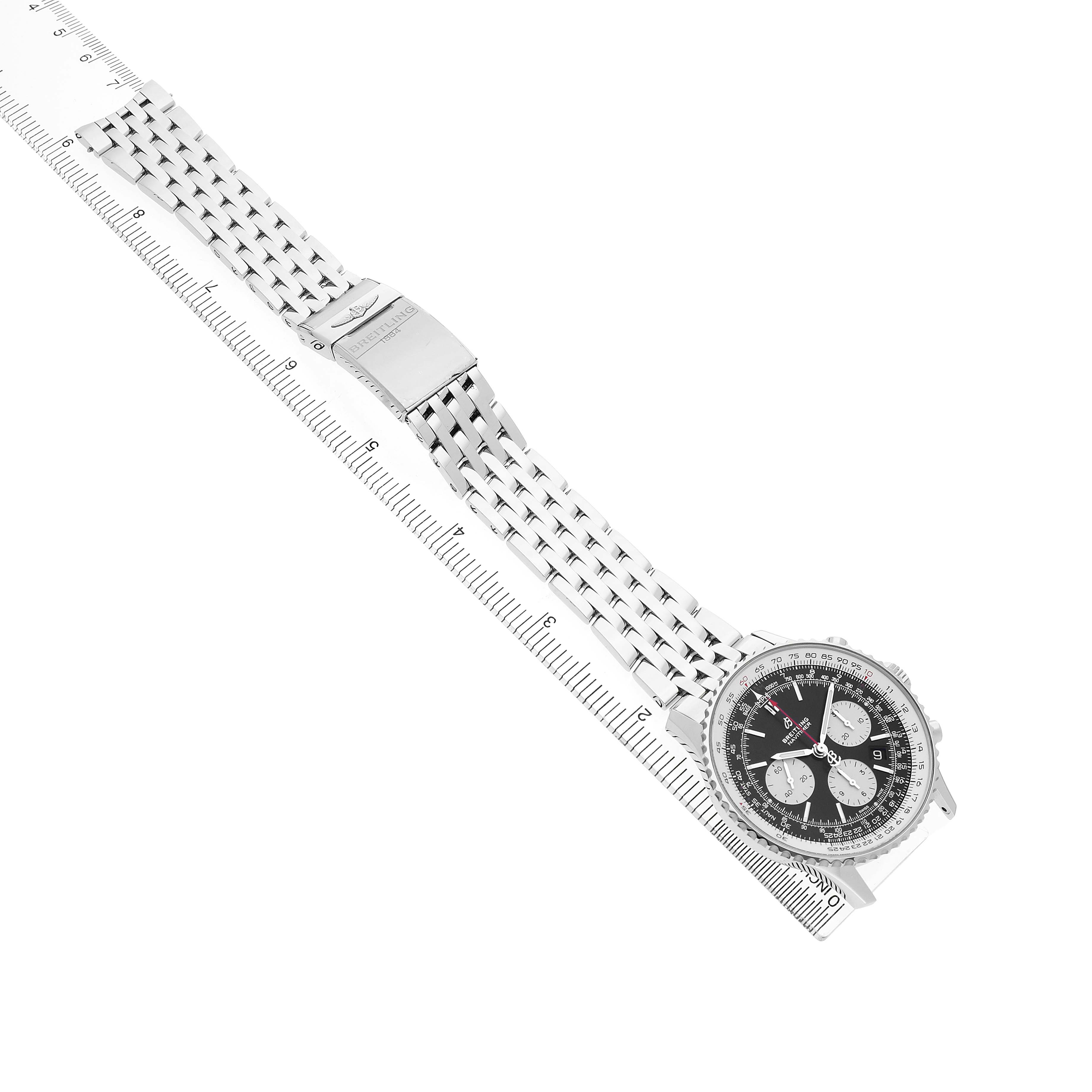 The Breitling Navitimer AB0121 Men's Stainless Steel Black Dial watch is shown diagonally with its face and bracelet fully visible, aligned with a measuring ruler.