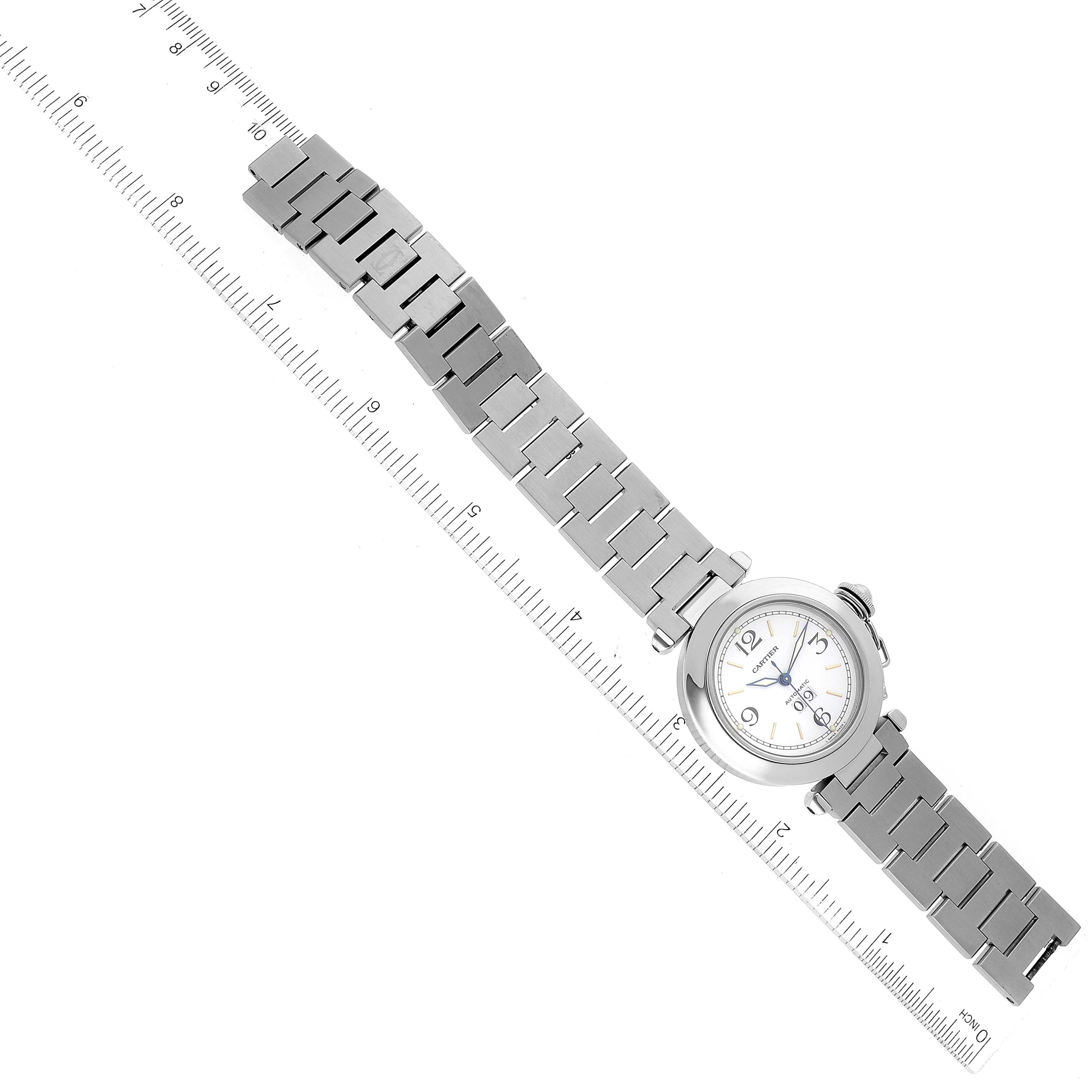 The image shows a top-down view of a Pasha model watch by Cartier with its metal bracelet fully extended alongside a ruler.