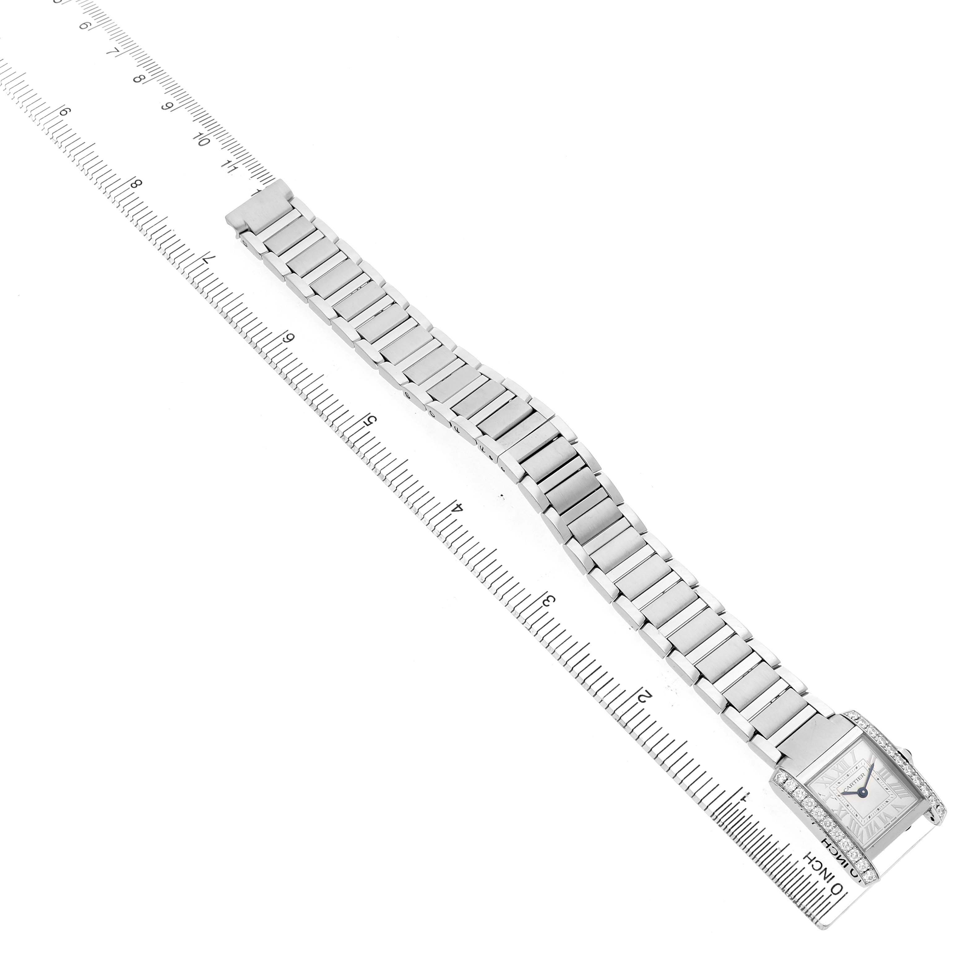 The Cartier Tank Française watch is shown at an overhead angle, displaying its entire bracelet and face beside a ruler for scale.