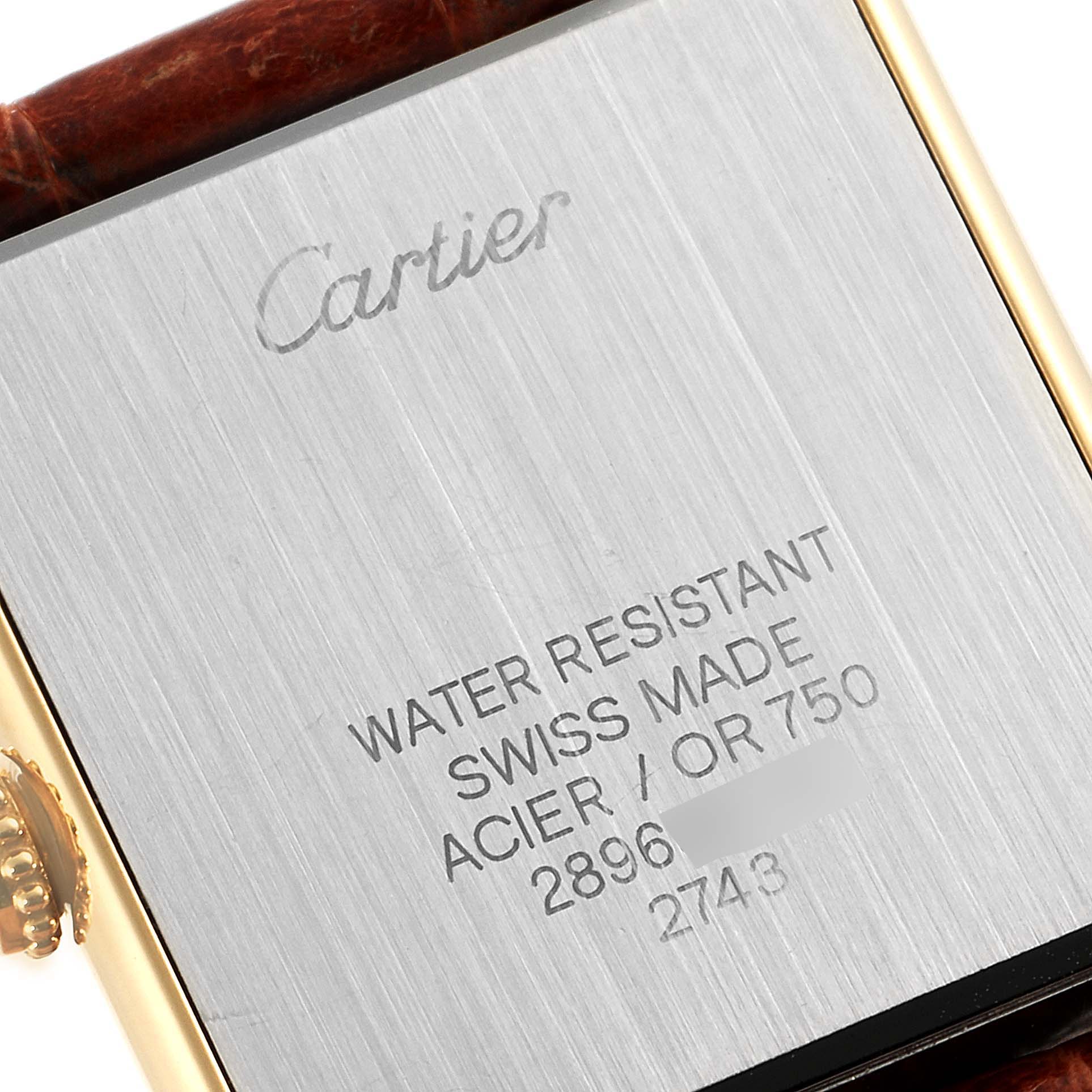 The image shows the back case of a Cartier Tank Solo W1018755 Women's Yellow Gold Silver Dial W1018755 Women's Yellow Gold Silver Dial watch, highlighting its inscriptions and part of the bracelet.
