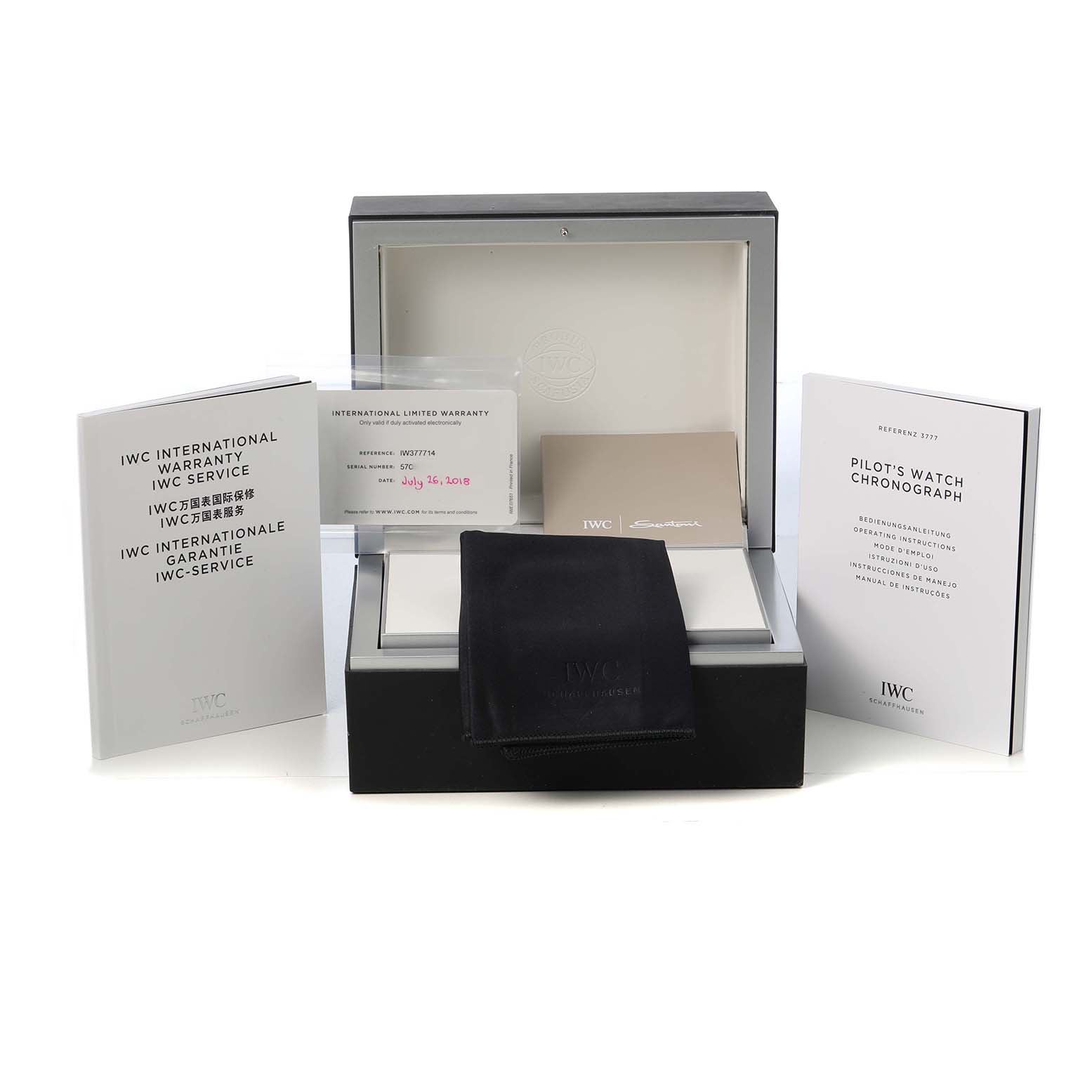 The image shows the IWC Pilot IW377714 Men's Stainless Steel Blue Dial watch packaging, warranty card, manuals, and a cleaning cloth.