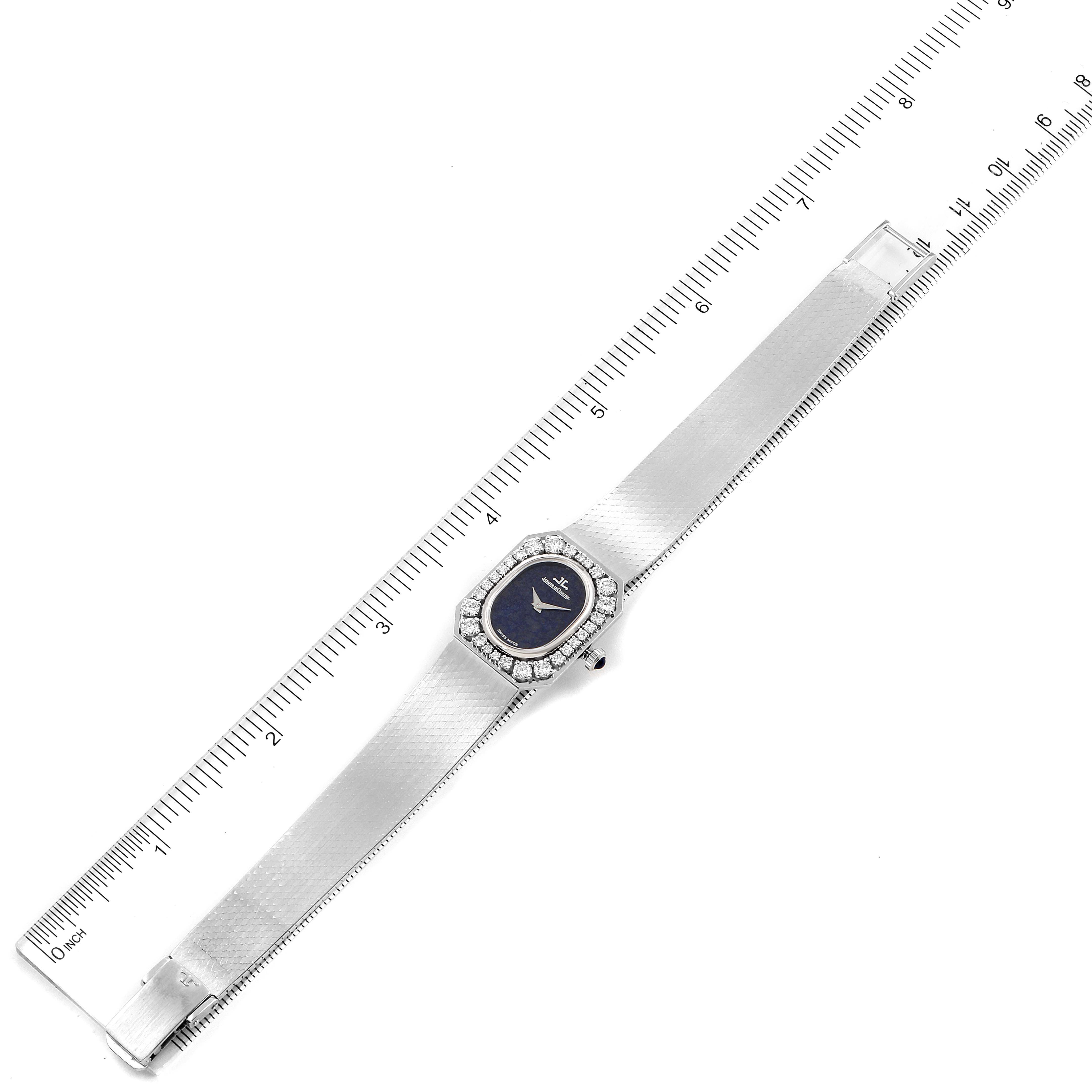 The Jaeger LeCoultre Vintage 16315.22 Women's White Gold Blue Dial 16315.22 Women's White Gold Blue Dial watch is shown from a top-down angle with its entire band and face visible alongside a ruler for scale.