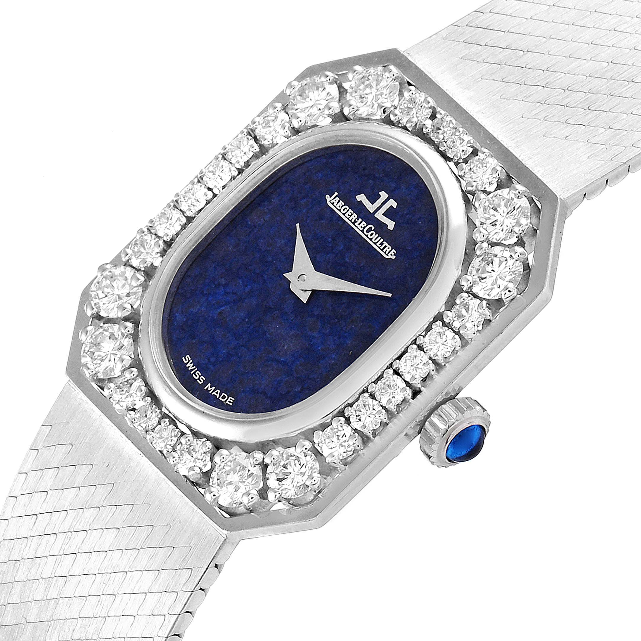 This image shows an angled view of a Vintage Jaeger LeCoultre watch featuring a blue dial, diamond bezel, crown with a blue cabochon, and a metal bracelet.