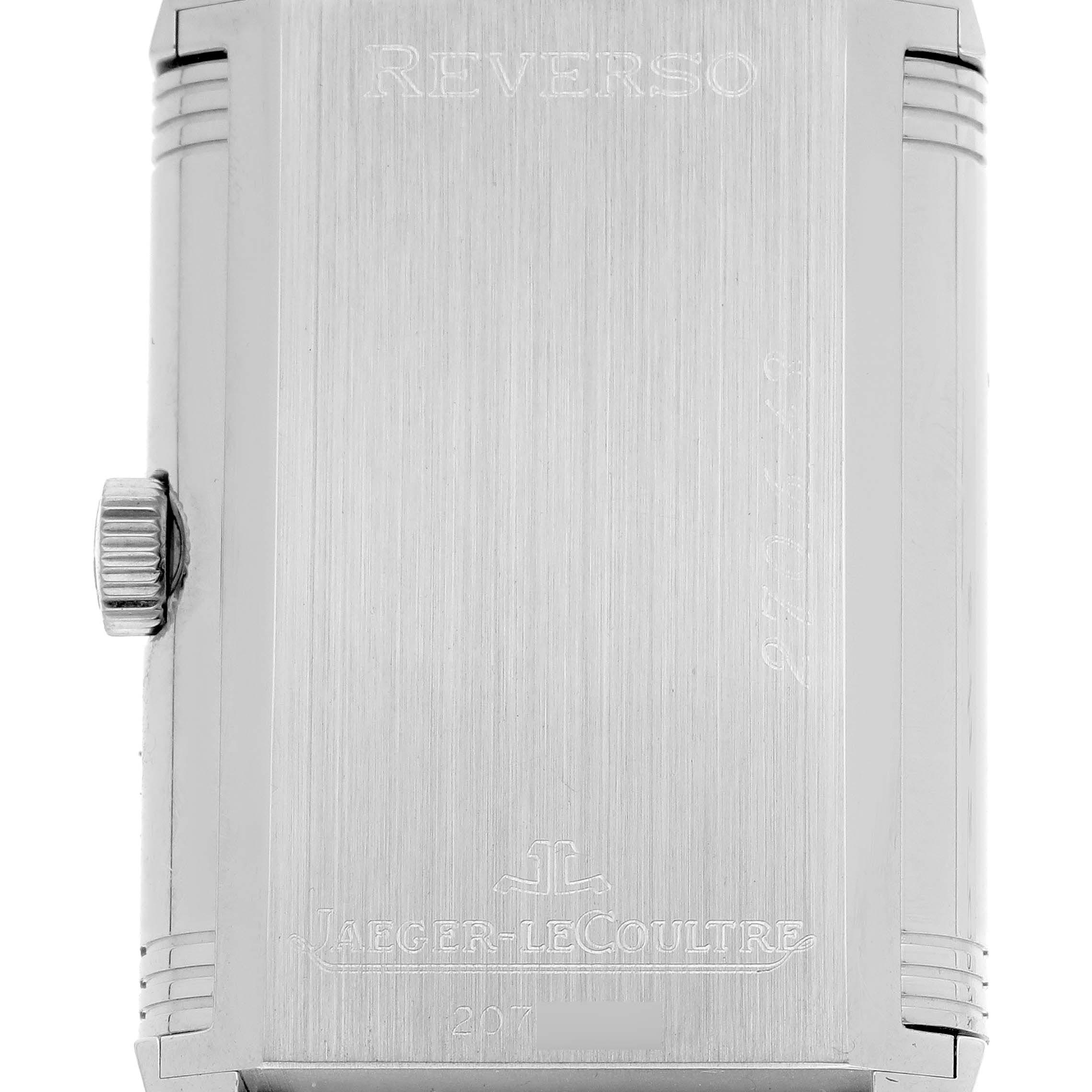 The image shows the back of a Jaeger-LeCoultre Reverso watch, highlighting its engraved details and side crown.