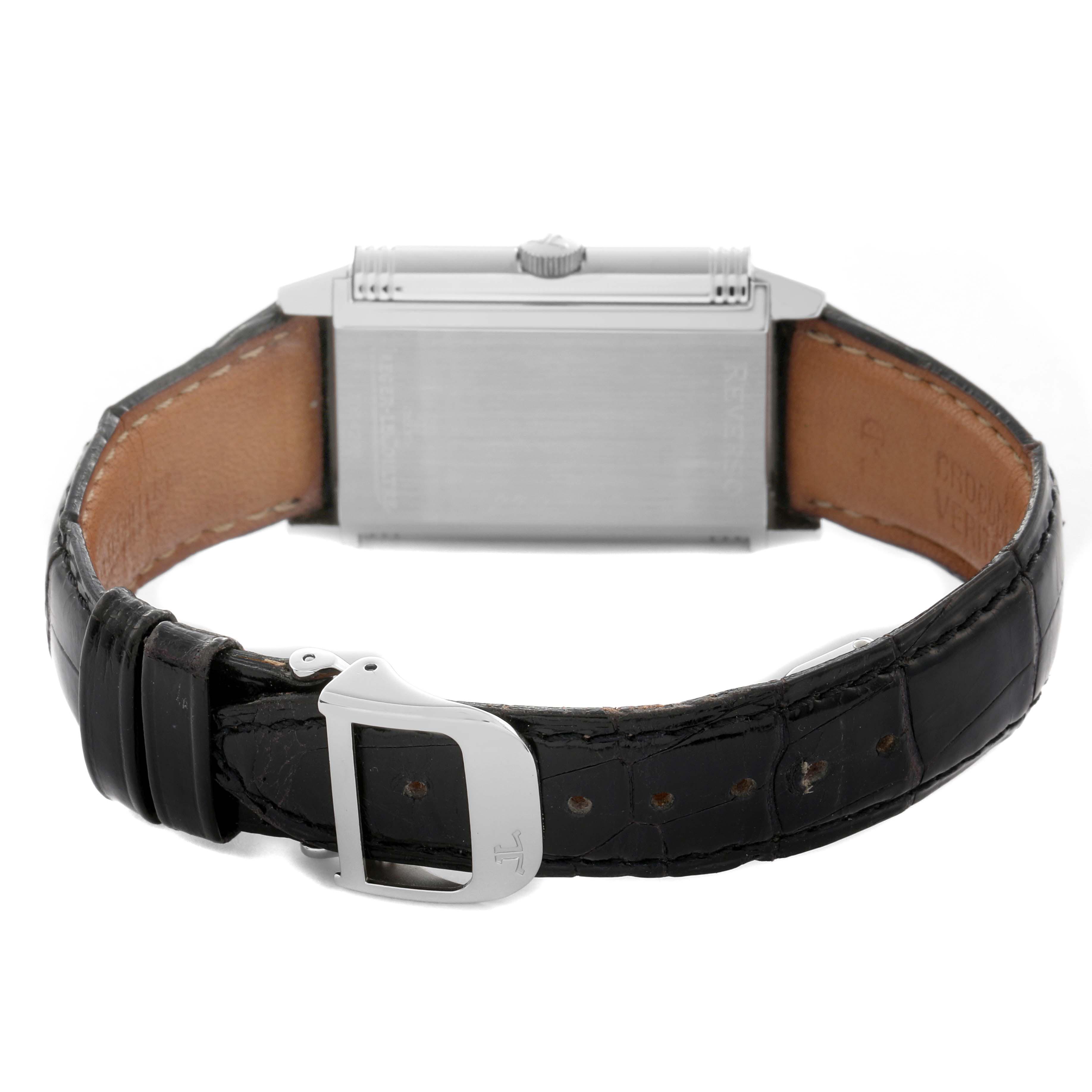 The Jaeger-LeCoultre Reverso watch is shown from the back, highlighting the case, crown, and black leather strap with buckle.
