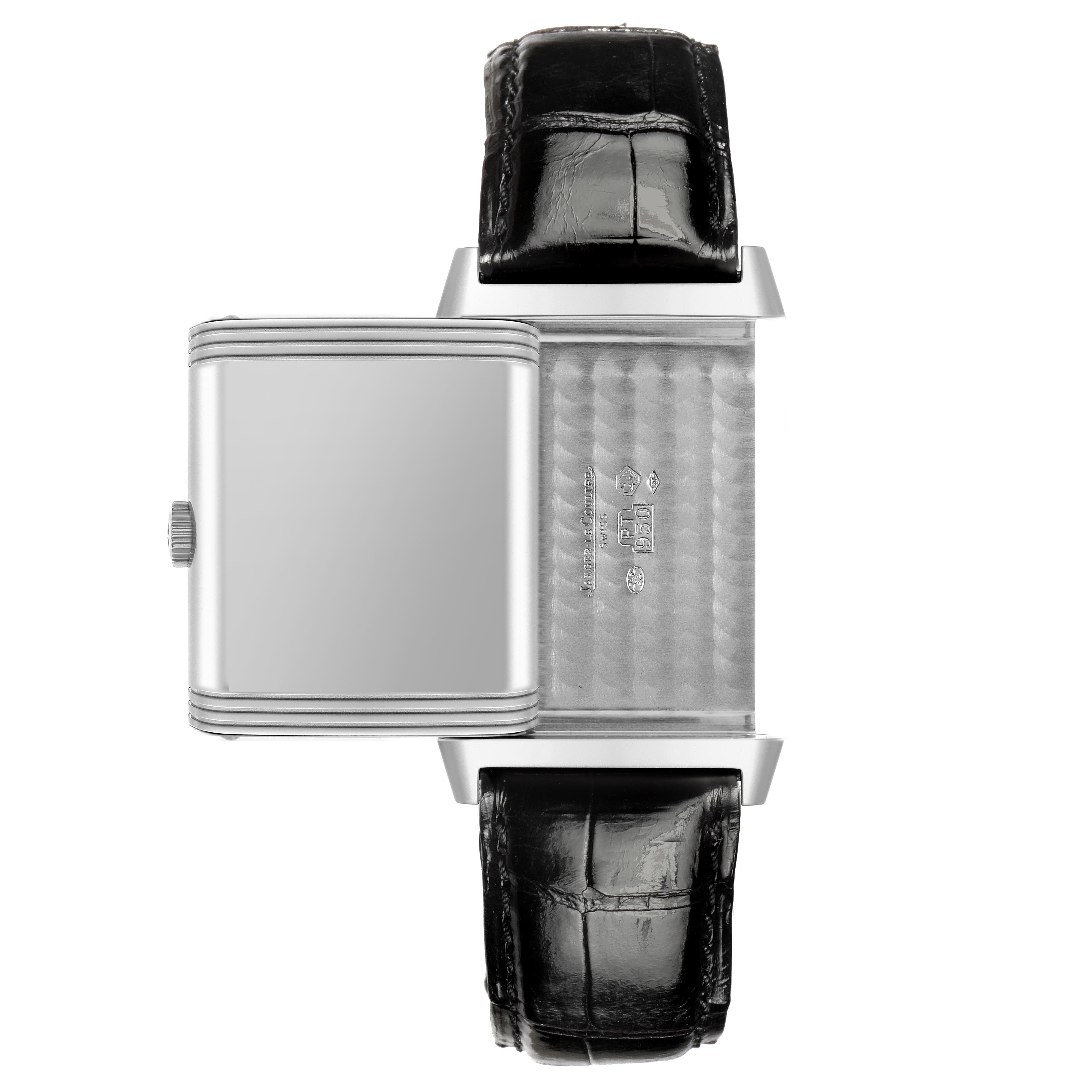 The image shows a Jaeger-LeCoultre Reverso watch from a top-down angle, revealing its rotating case and black leather strap.
