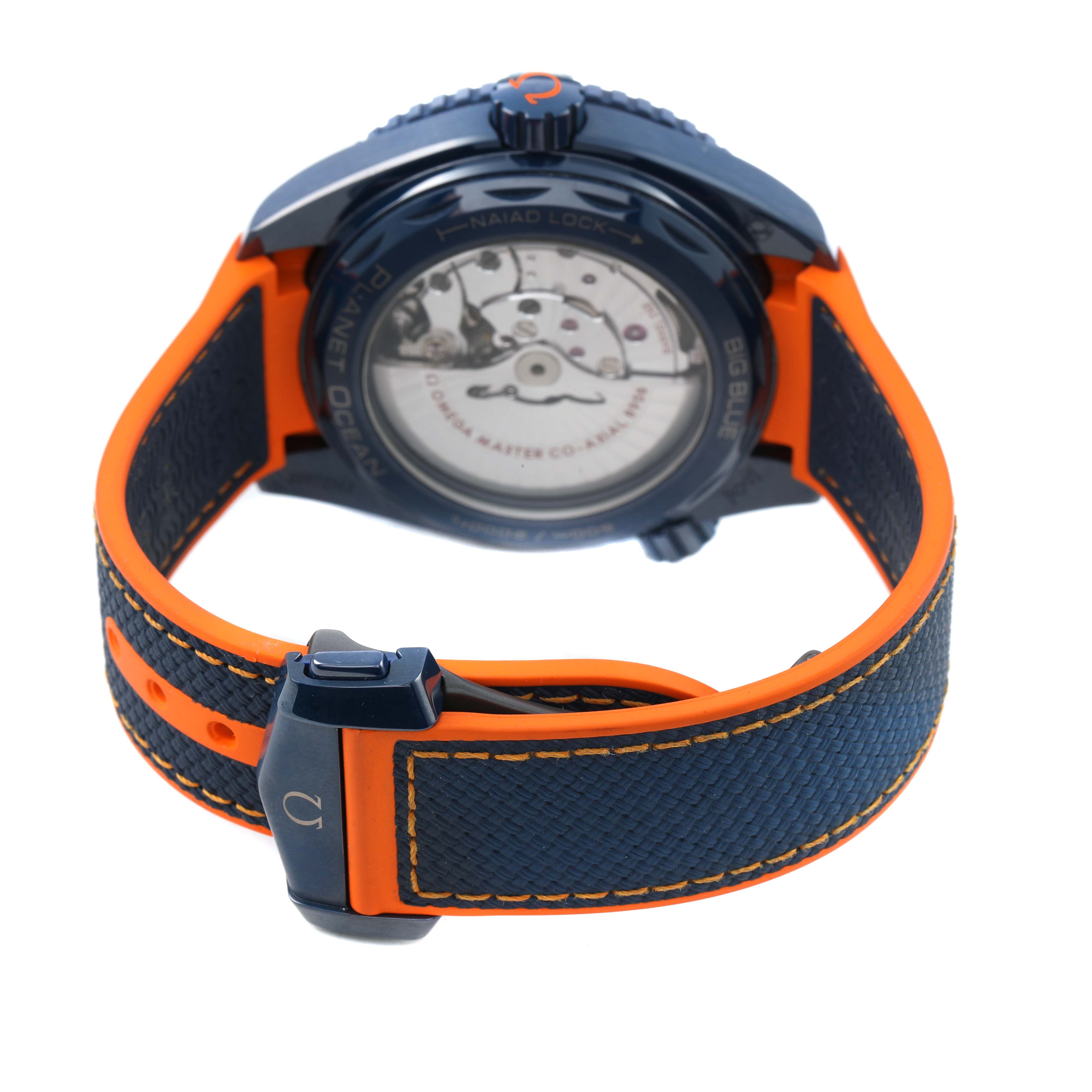 The Omega Planet Ocean 215.92.46.22.03.001 Men's Ceramic Blue Dial watch is shown from the rear, highlighting its open case back and vivid strap detailing.