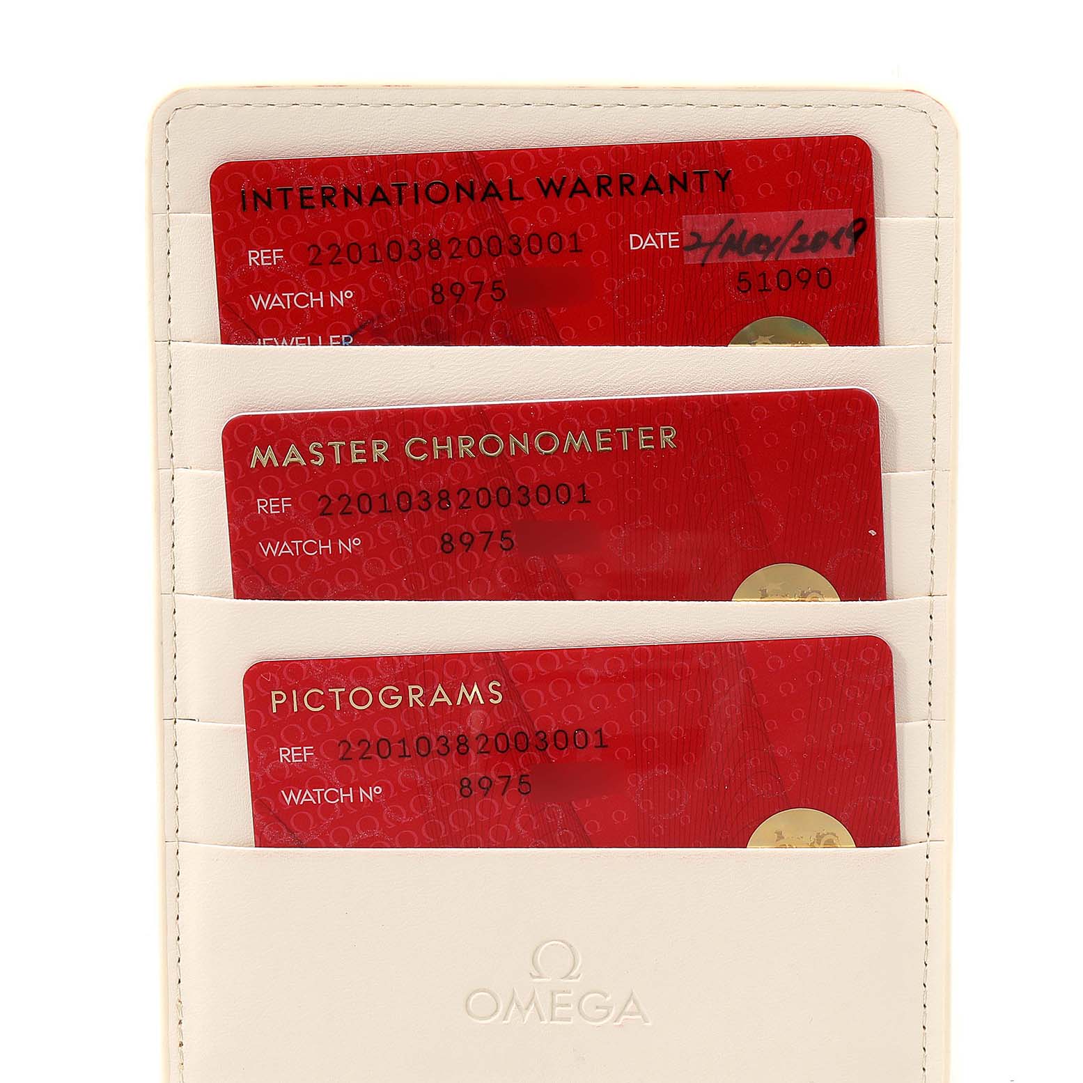 The image shows warranty, Master Chronometer, and pictogram cards for the Omega Aqua Terra 220.10.38.20.03.001 Men
s Stainless Steel Blue Dial 220.10.38.20.03.001 Men
s Stainless Steel Blue Dial model in a cream-colored cardholder.