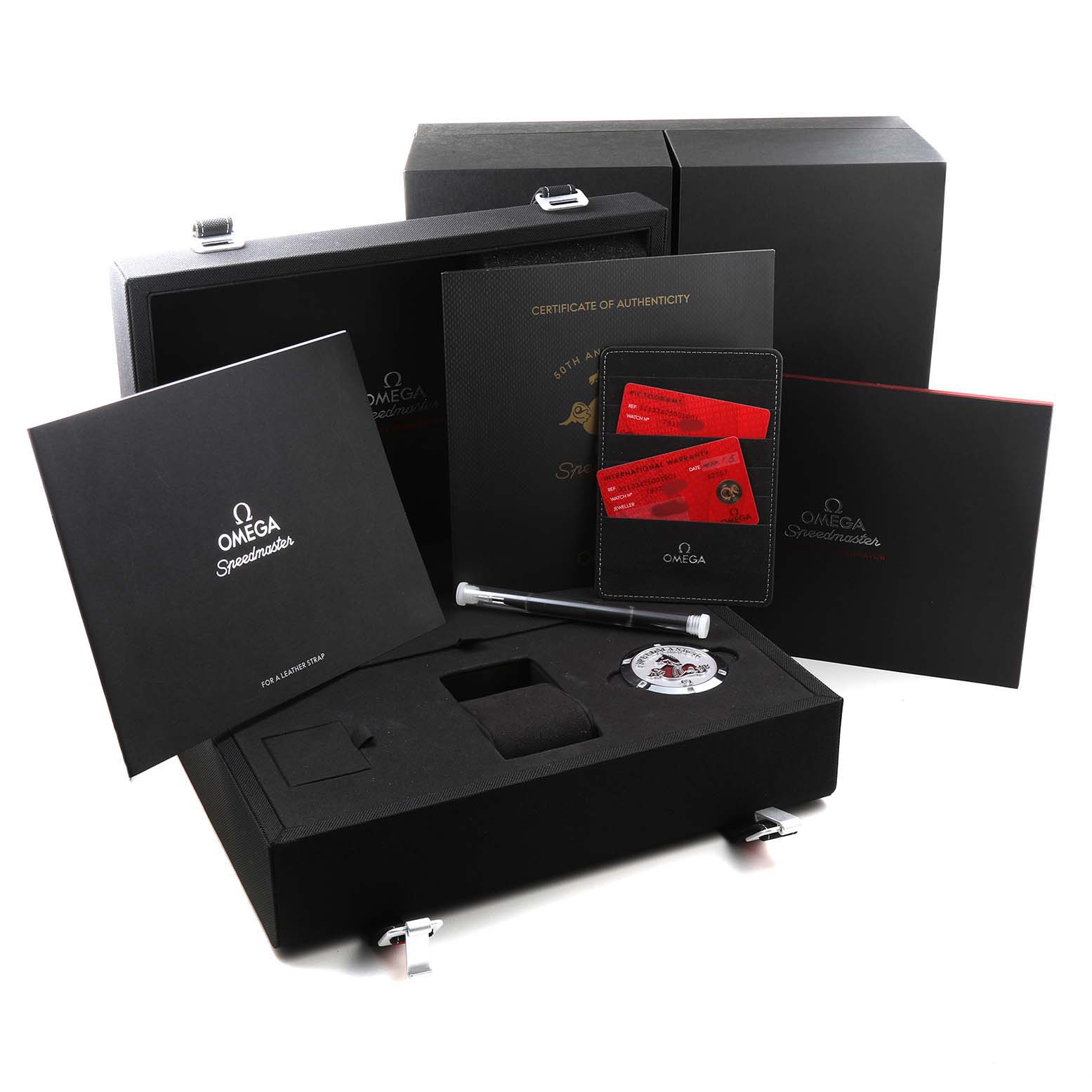 The image shows Omega Speedmaster 311.33.42.50.01.001 Men's Stainless Steel Black Dial packaging with accessories like a presentation box, certification, a case, and cards.