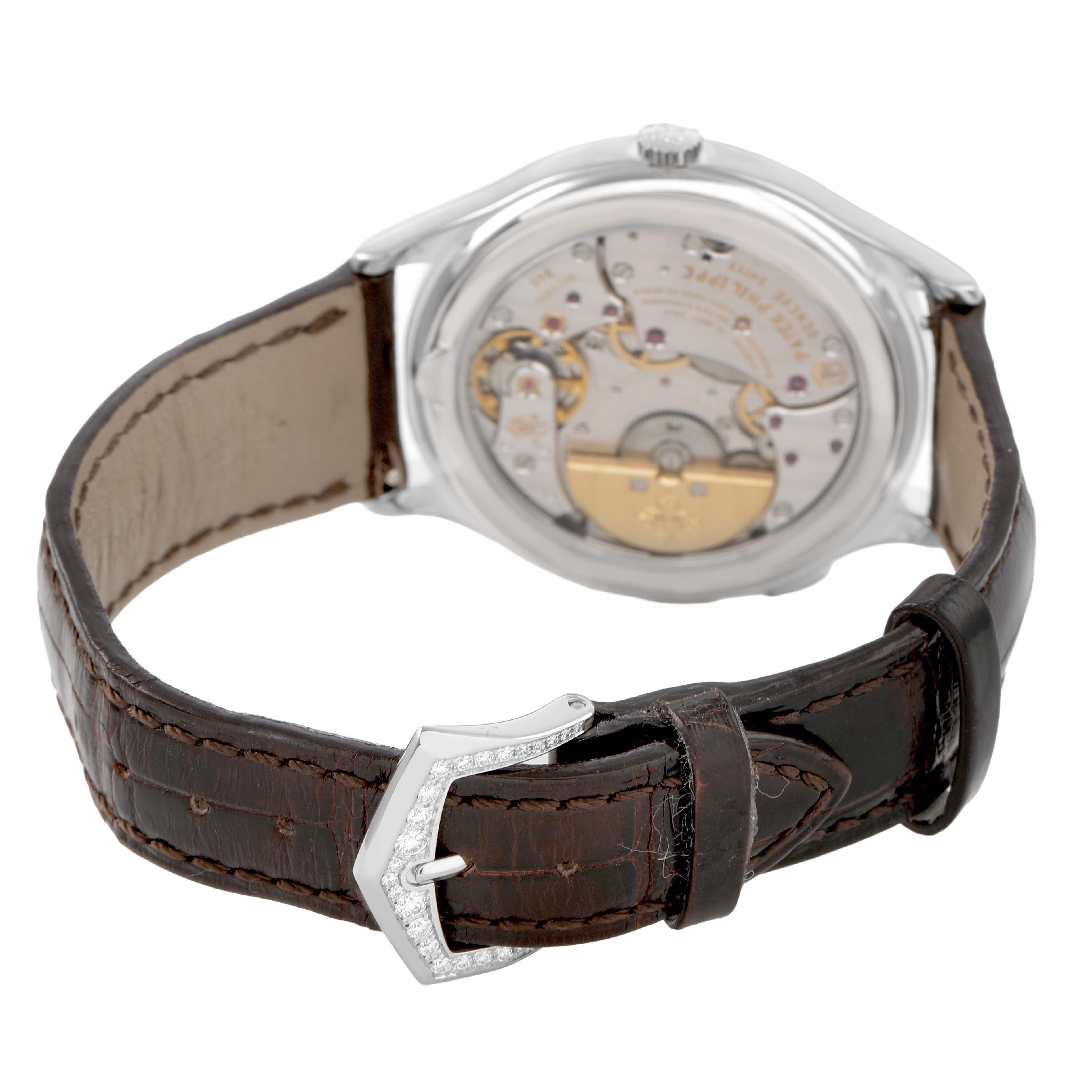 The image shows the back view of a Patek Philippe Complications 7130G Men's White Gold Brown Dial model, highlighting the movement and brown leather strap with a buckle.