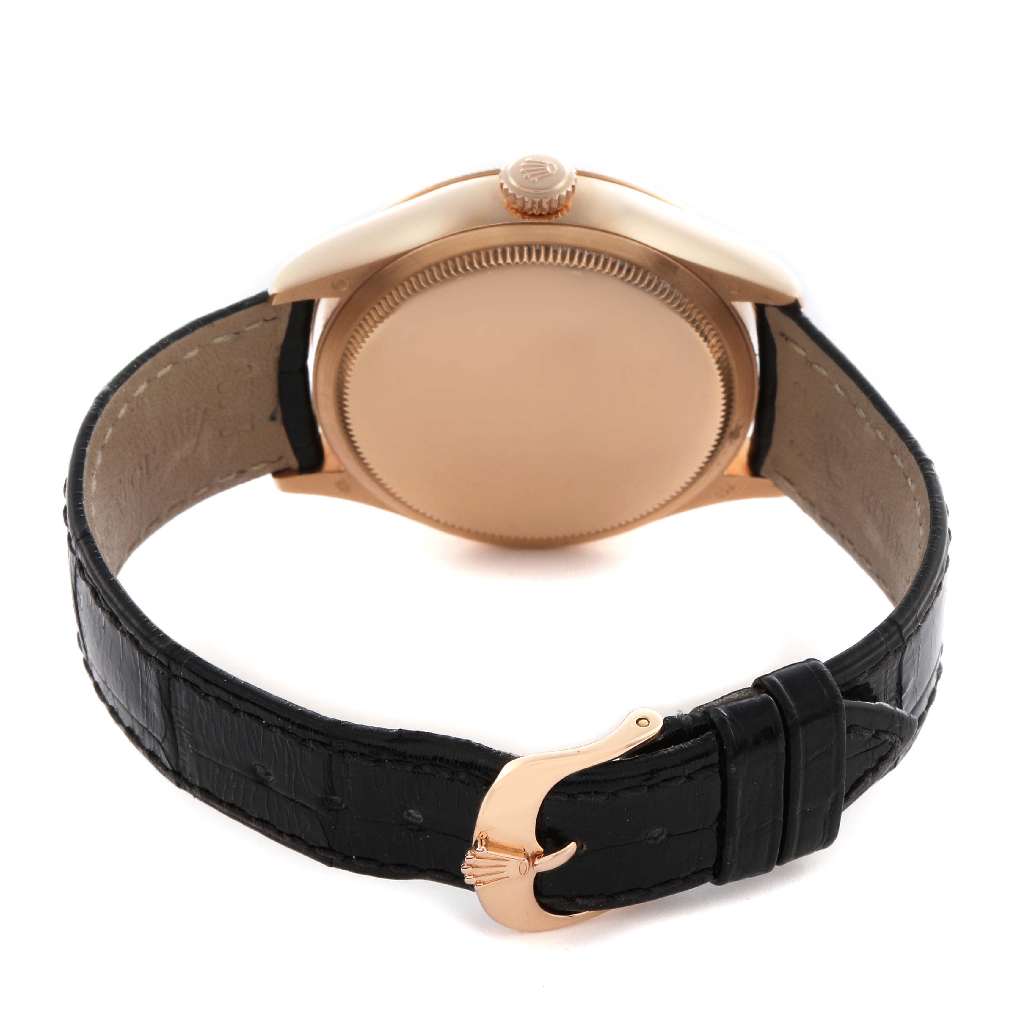 The image shows the back of a Rolex Cellini 50525 Men
s Rose Gold Black Dial 50525 Men
s Rose Gold Black Dial watch, featuring its case, crown, and black strap with a gold buckle.