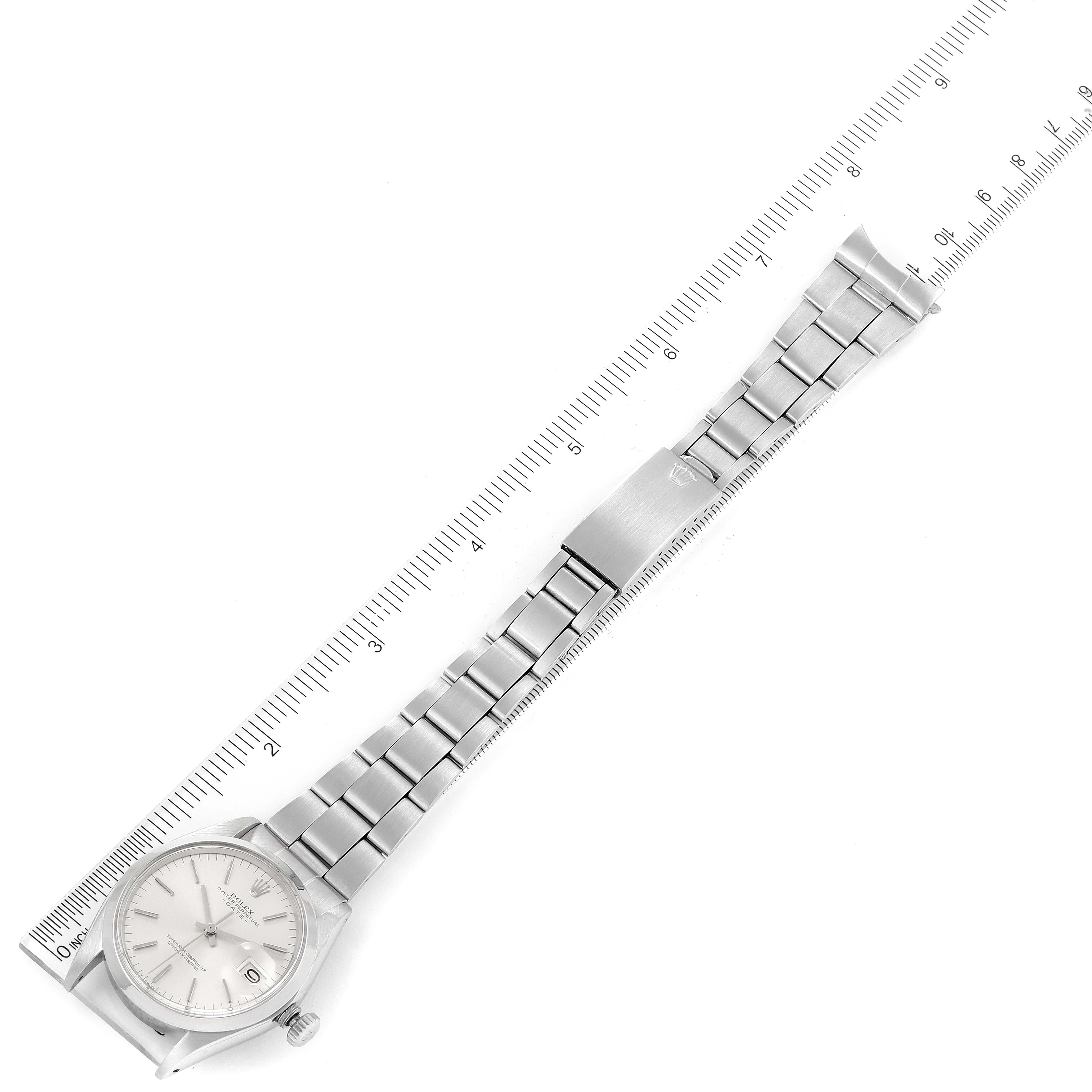 The image shows a top view of a Rolex Date 1500 Men's Stainless Steel Silver Dial 1500 Men's Stainless Steel Silver Dial model watch with its full metal bracelet and a measuring ruler in the background.
