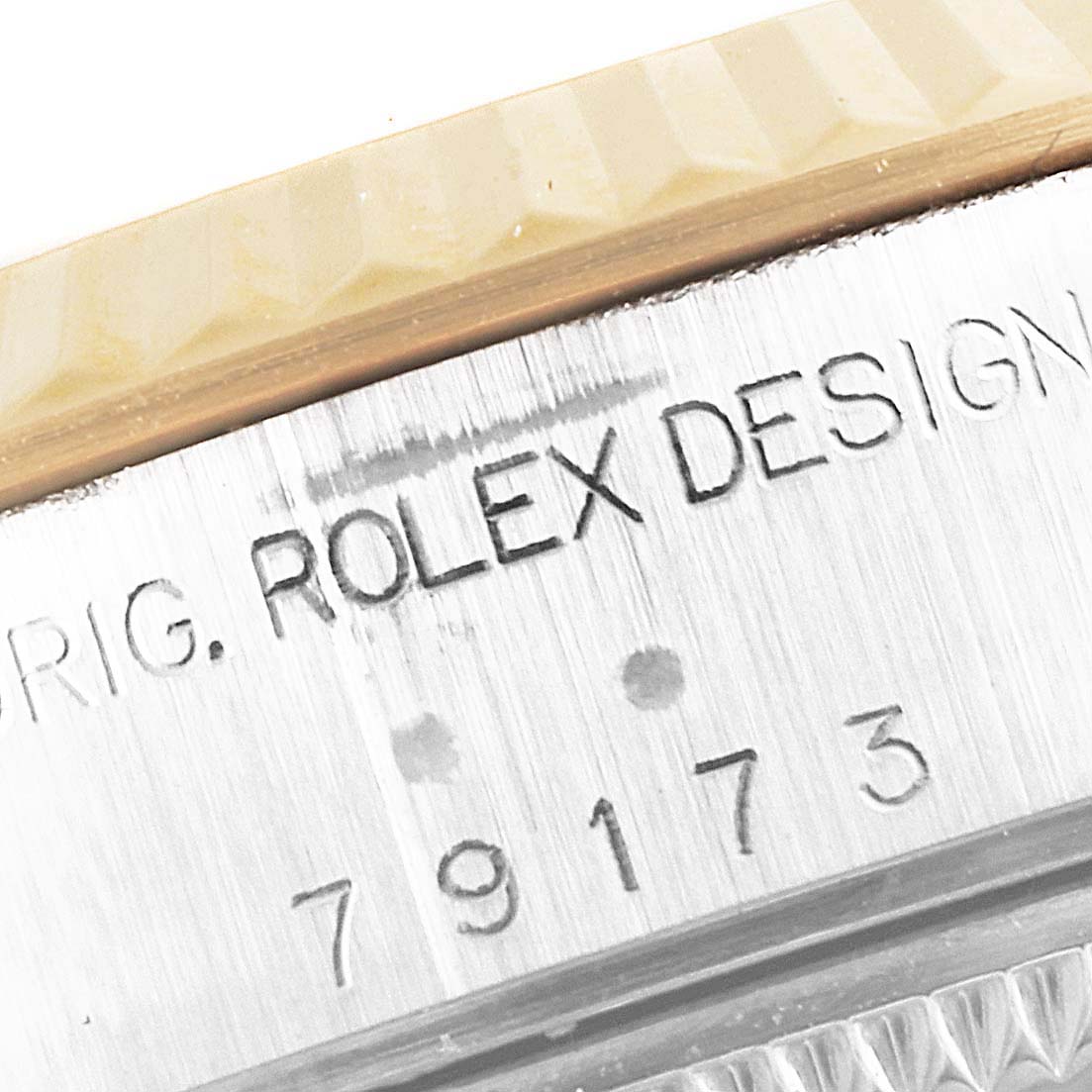 This close-up image shows the side view of a Rolex Datejust 79173 Women's Steel and Gold (two tone) Mother of Pearl Dial 79173 Women's Steel and Gold (two tone) Mother of Pearl Dial watch case, displaying the model number and "Rolex Design" engraving.