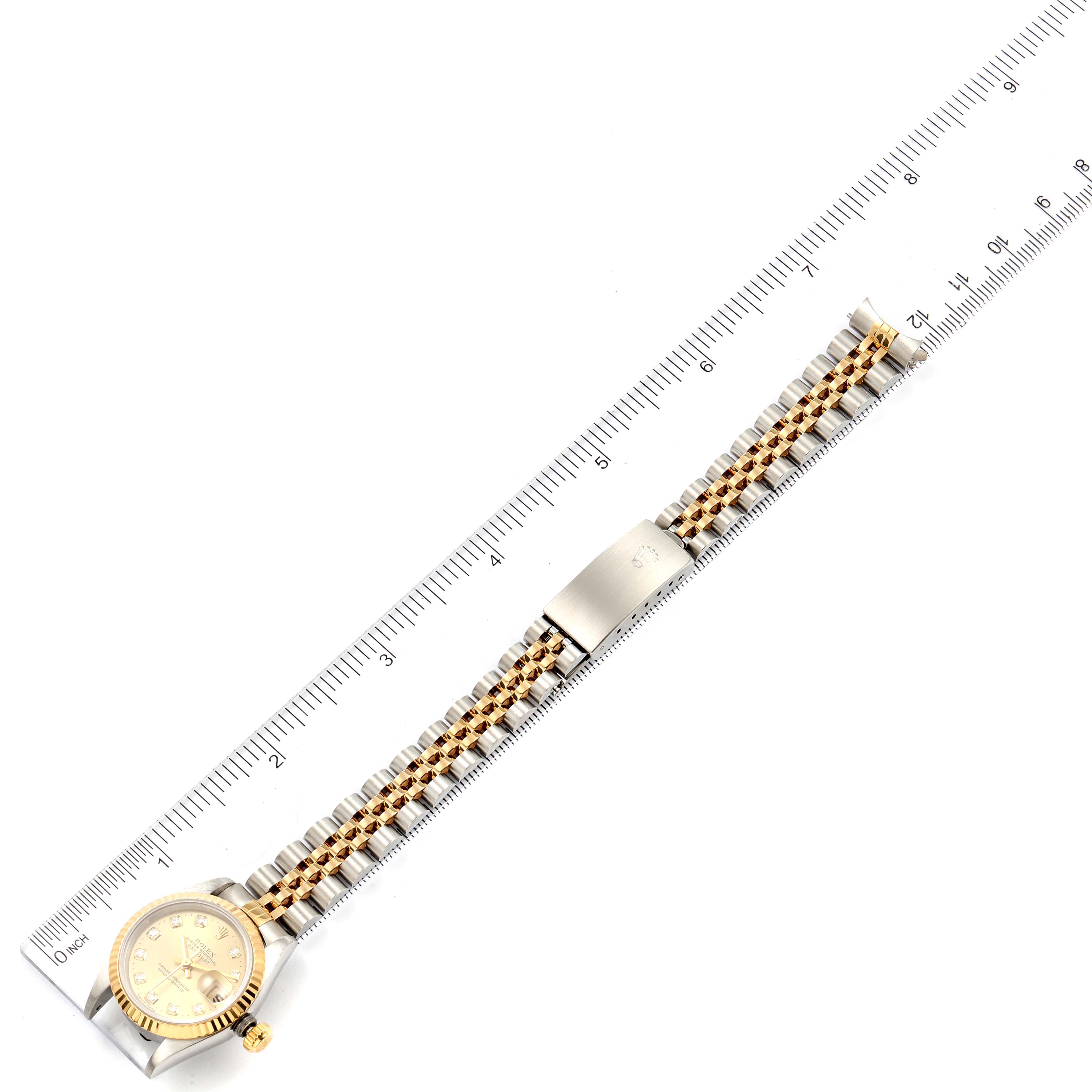 The Rolex Datejust 69173 Women's Steel and Gold (two tone) Champagne Dial 69173 Women's Steel and Gold (two tone) Champagne Dial watch is shown from a top-down angle alongside a ruler for measurement, highlighting its two-tone bracelet and clasp.