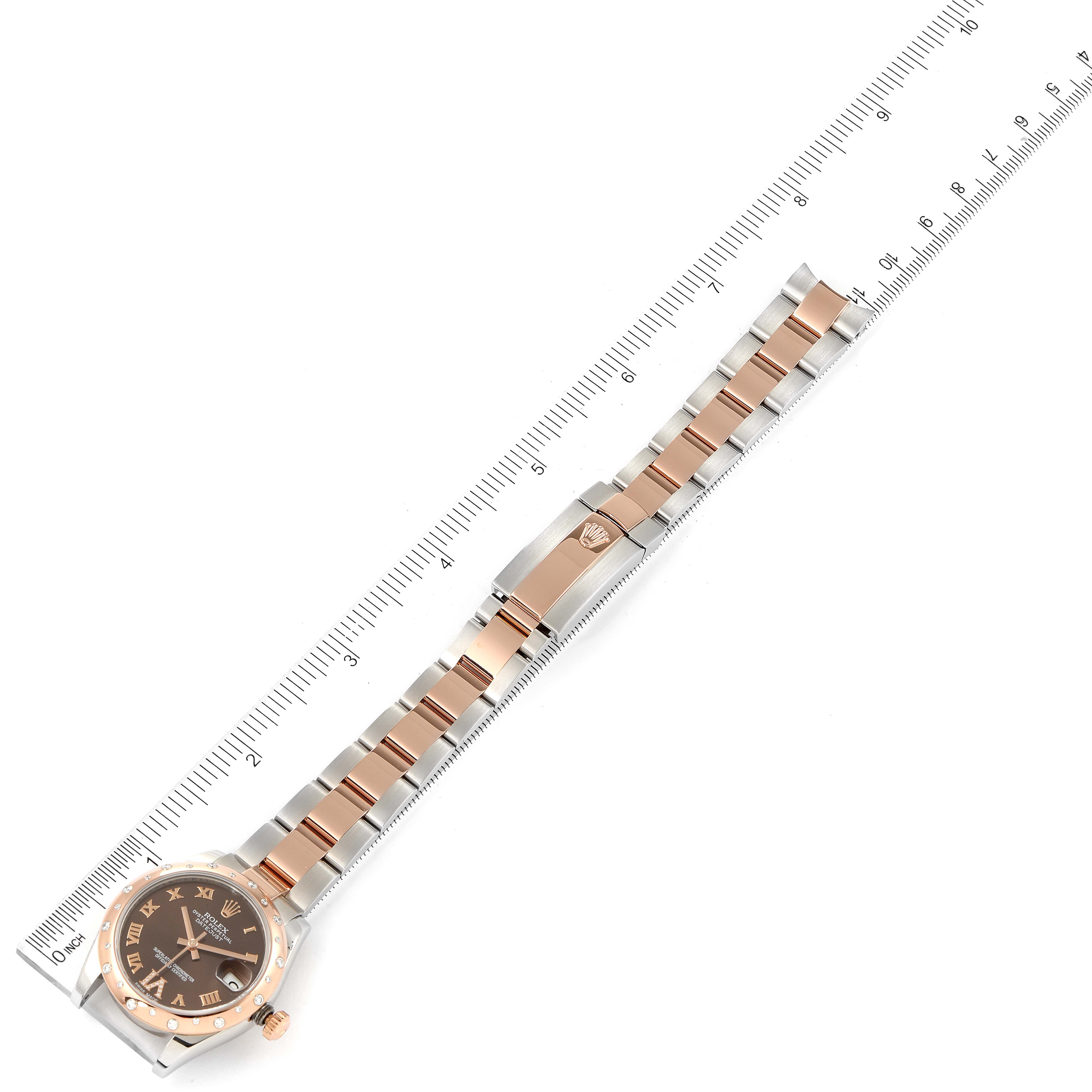 The image shows a Rolex Mid-Size 178341 Women's Steel and Gold (two tone) Brown Dial 178341 Women's Steel and Gold (two tone) Brown Dial watch laid flat with a metal band and deployant clasp, measured against a ruler.