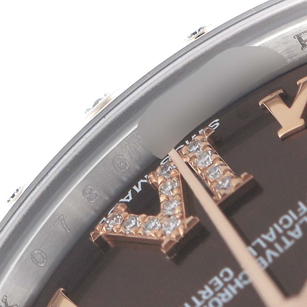 This close-up of the Rolex Mid-Size 178341 Women's Steel and Gold (two tone) Brown Dial 178341 Women's Steel and Gold (two tone) Brown Dial model shows the bezel, part of the dial, and diamond-set Roman numerals.