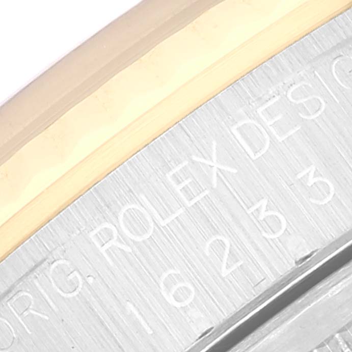 This close-up shows the engraved case side of a Rolex Datejust 16233 Men's Steel and Gold (two tone) Blue Dial 16233 Men's Steel and Gold (two tone) Blue Dial watch.