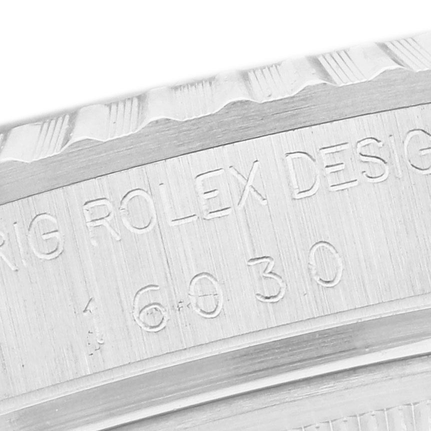 The image shows a close-up of the engraved side of a Rolex Datejust 16030 Men
s Stainless Steel Silver Dial 16030 Men
s Stainless Steel Silver Dial watch case, highlighting the model number and brand.
