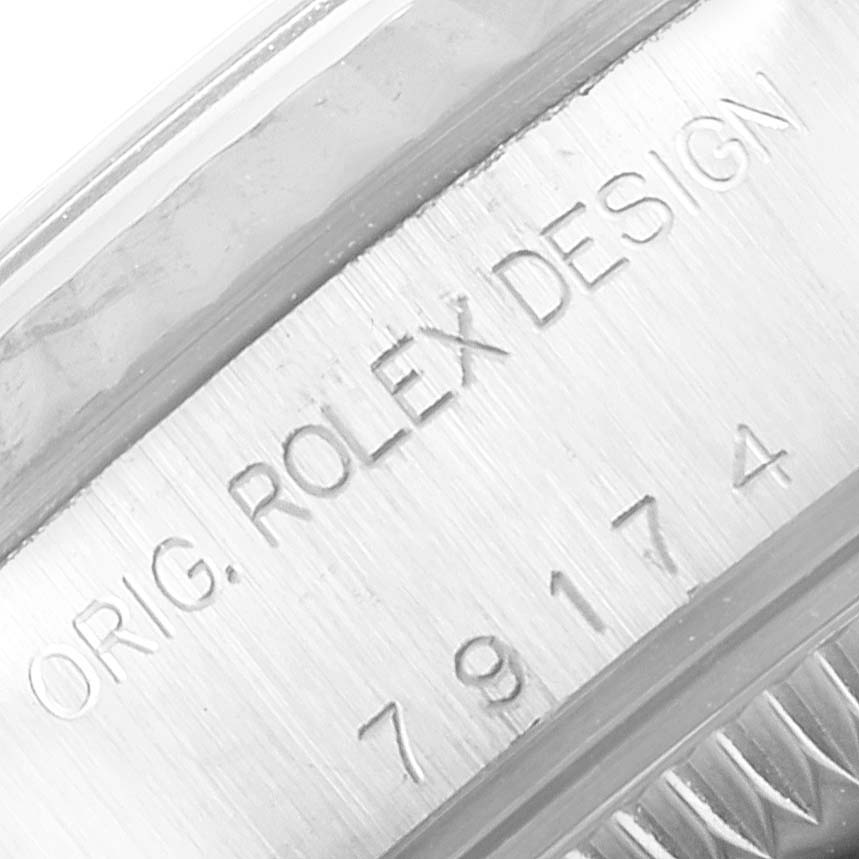 The image shows a close-up of the engraved text "ORIG. ROLEX DESIGN" and part of the model number on the side of a Rolex Datejust 79174 Women's Stainless Steel Black Dial 79174 Women's Stainless Steel Black Dial bezel.