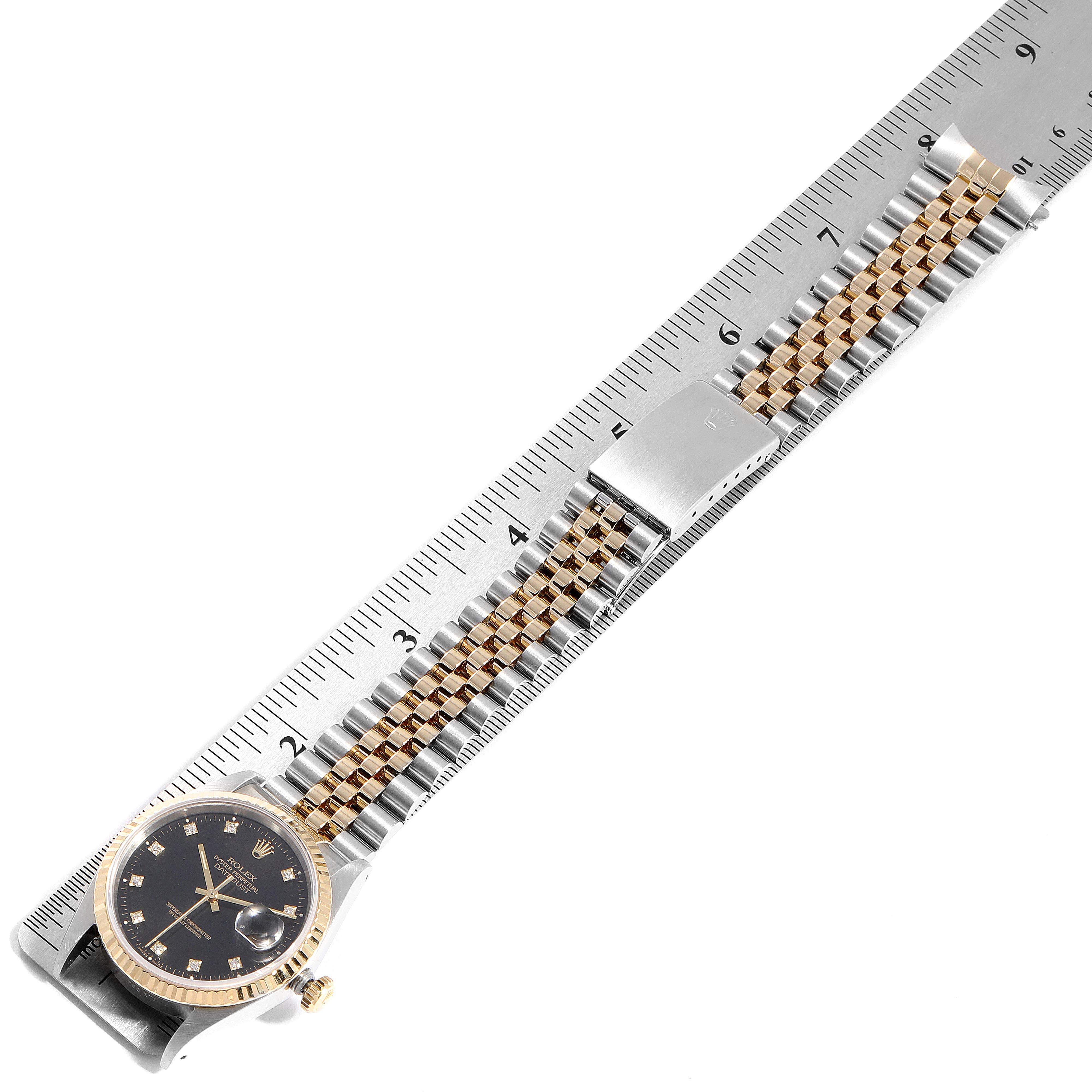 The Rolex Datejust 41 16233 Men's Steel and Gold (two tone) Black Dial 16233 Men's Steel and Gold (two tone) Black Dial is shown from a bird's-eye view, displaying its face, crown, and bracelet along a ruler for scale.