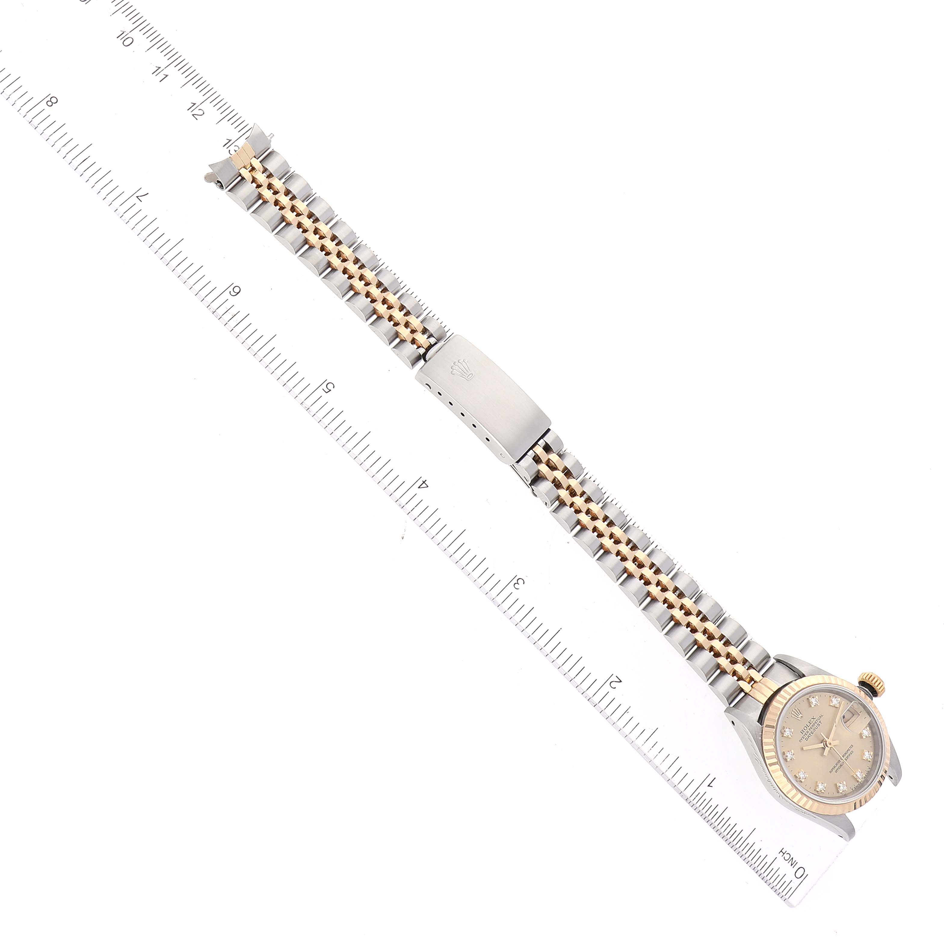 The image shows a top-view angle of a Rolex Datejust 69173 Women's Steel and Gold (two tone) Champagne Dial 69173 Women's Steel and Gold (two tone) Champagne Dial watch displaying the full bracelet and the watch face alongside a ruler for scale.