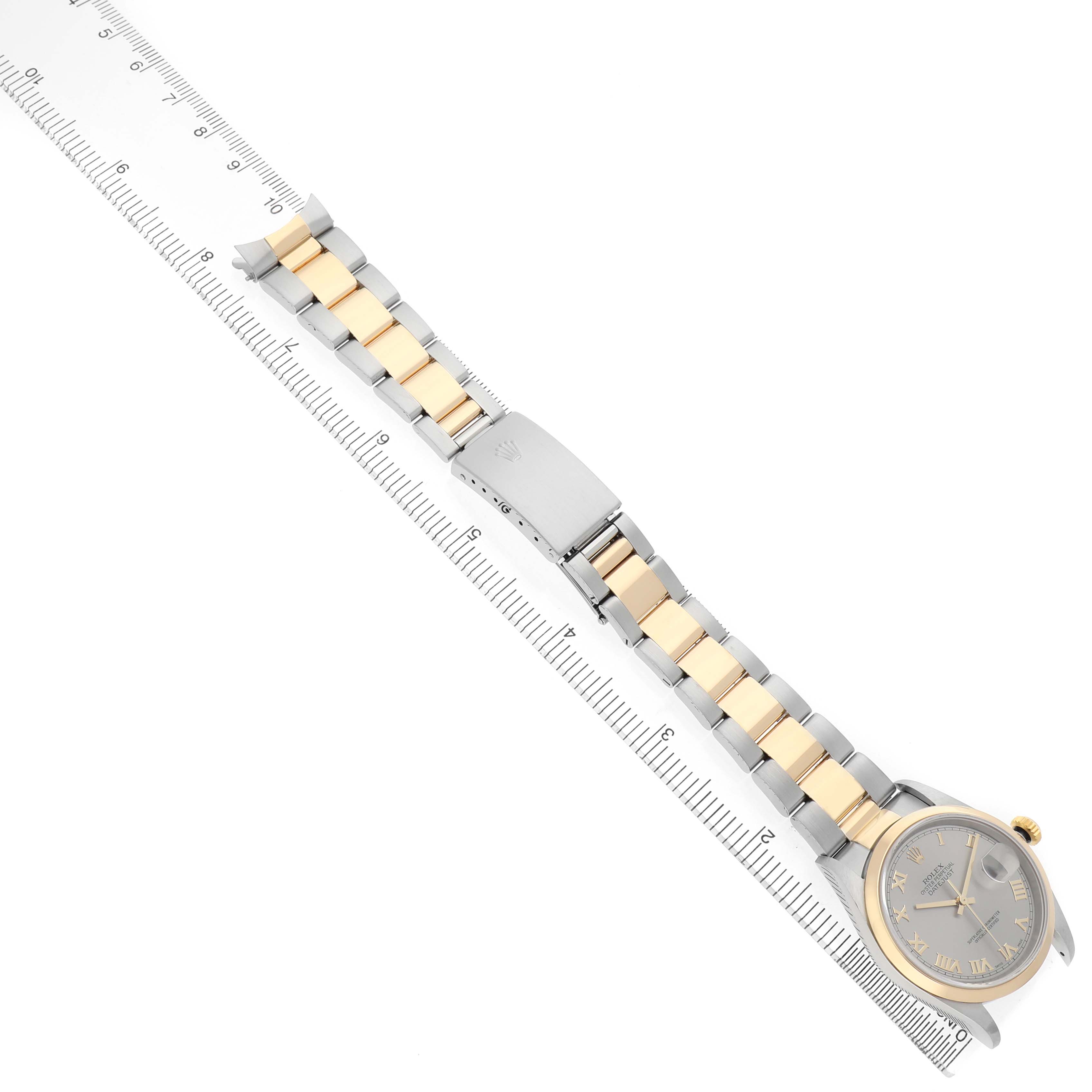 The Rolex Datejust 16203 Men's Steel and Gold (two tone) Silver Dial watch is shown from above, highlighting its two-tone bracelet and clasp alongside a ruler for scale.