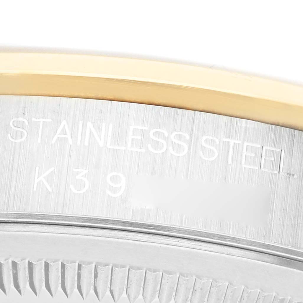 The image shows a close-up of the Rolex Datejust 16203 Men's Steel and Gold (two tone) Silver Dial model's case edge with engraved "STAINLESS STEEL" text and part of the bezel.