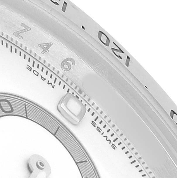 This image shows a close-up of the bezel and part of the dial of a Rolex Daytona 116520 Men's Stainless Steel White Dial, highlighting the tachymetric scale and indices.