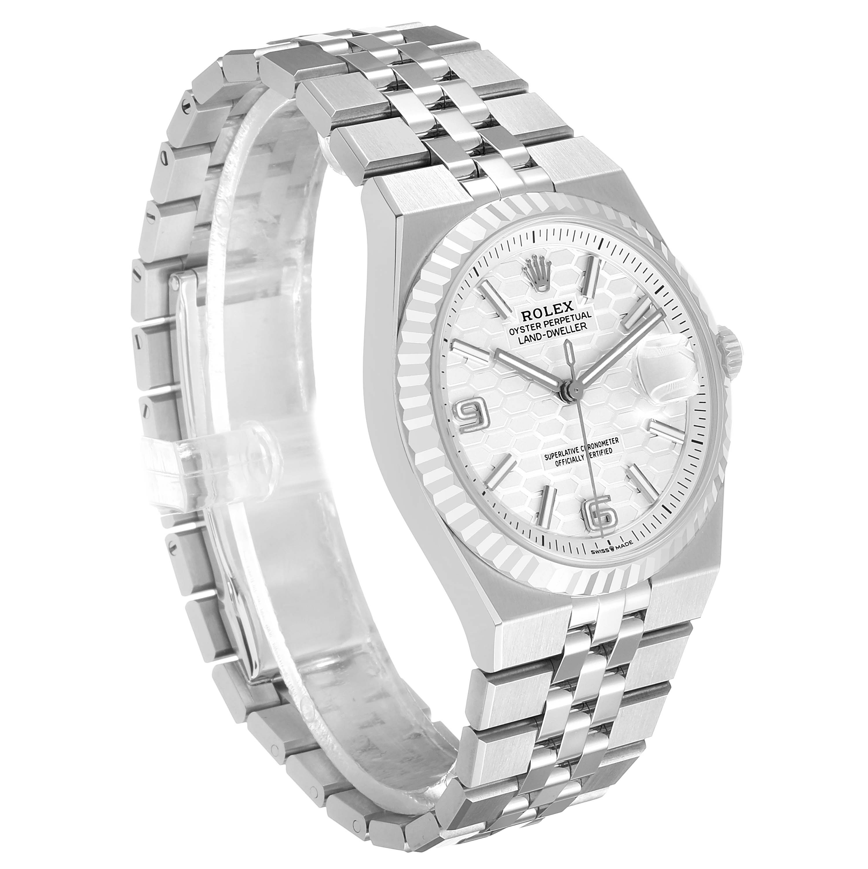 The Rolex Land-Dweller watch is shown at a slight angle, featuring its face, bezel, and bracelet.