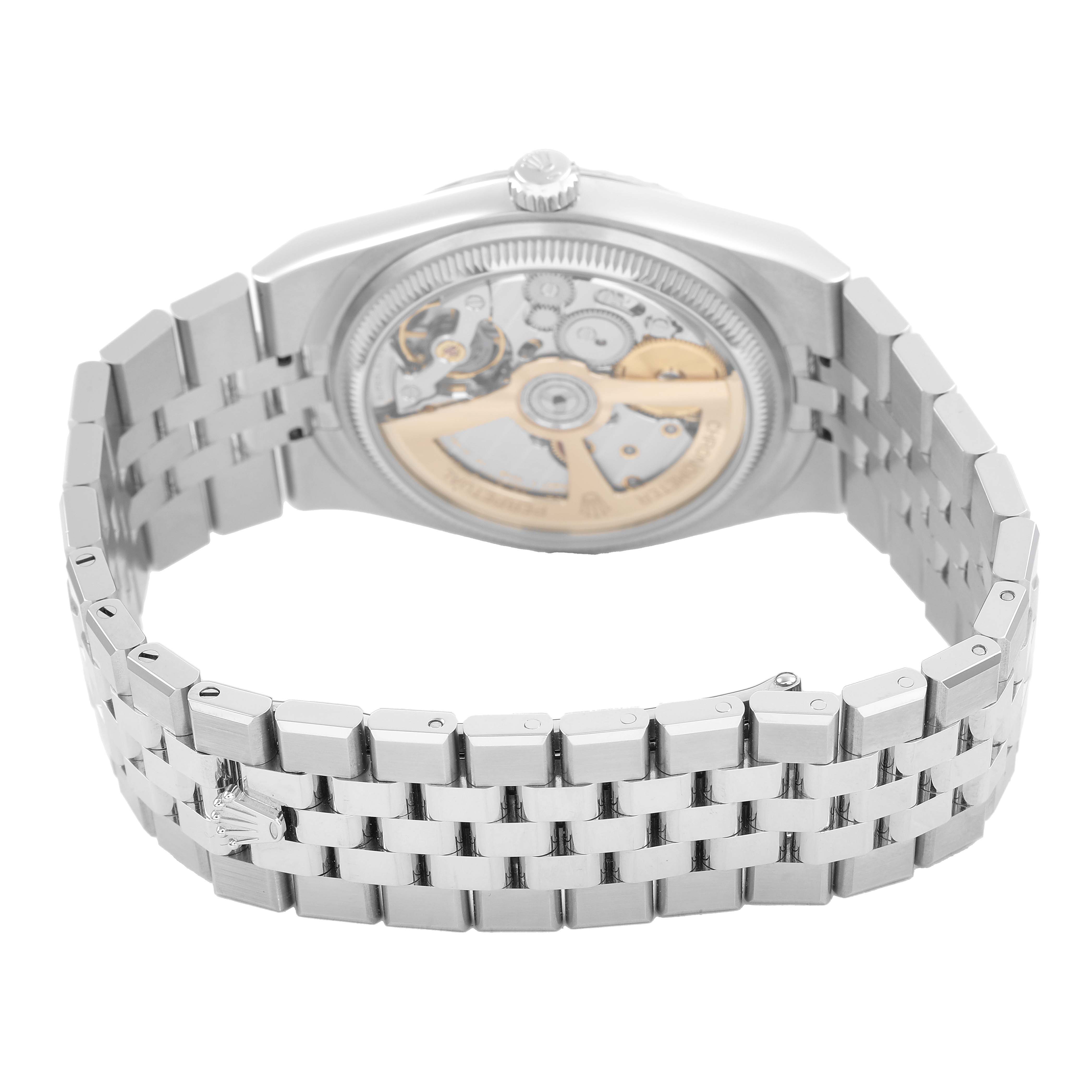 The Rolex Land-Dweller watch is shown from the back, displaying its open case back and metal bracelet.