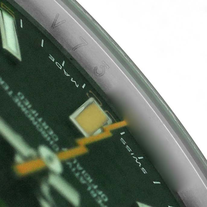 The image shows a close-up of the dial edge and part of the second hand of a Rolex Milgauss 116400GV Men's Stainless Steel Black Dial watch.