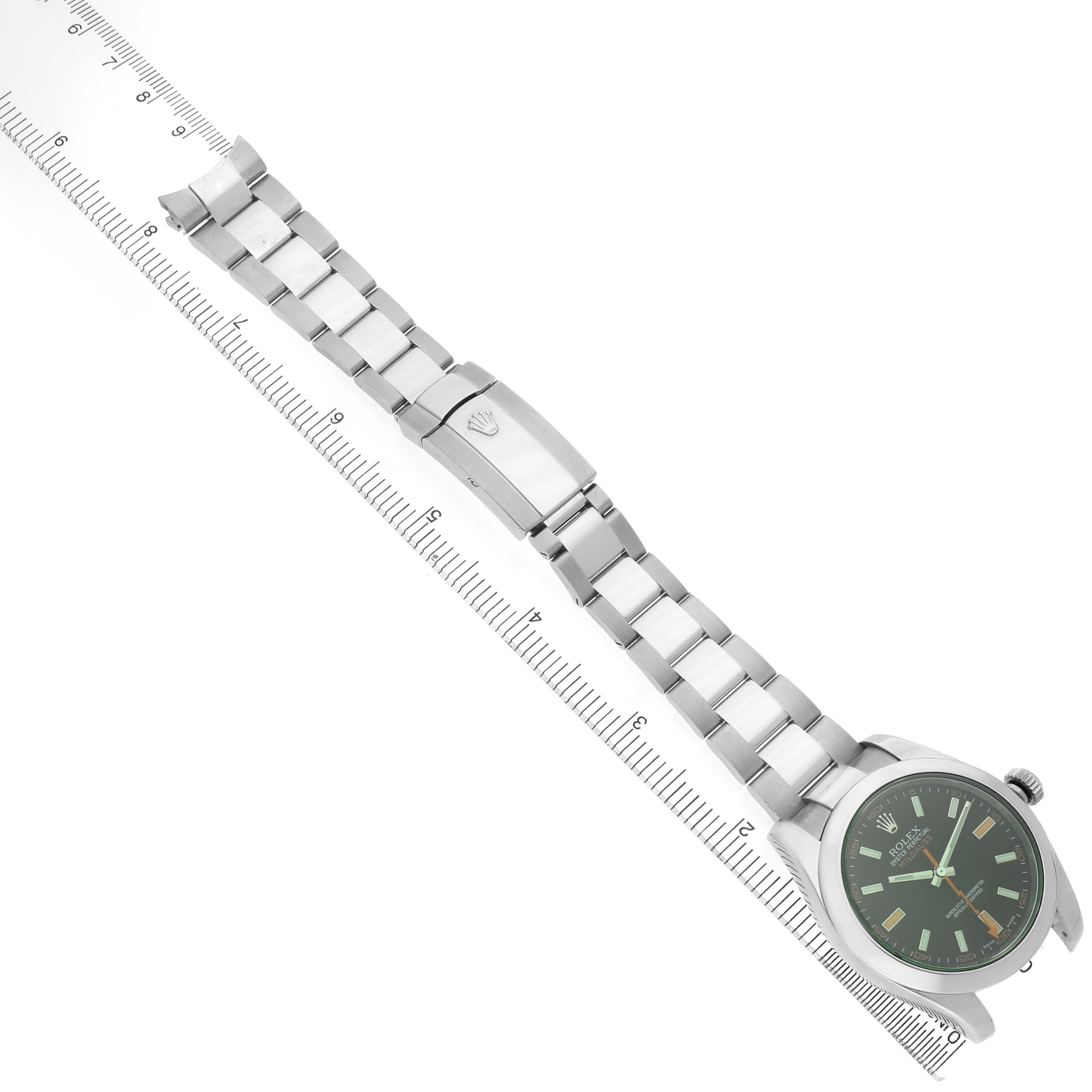 The Rolex Milgauss 116400GV Men's Stainless Steel Black Dial watch is shown at a top-down angle, displaying the face, metal bracelet, and clasp alongside a ruler.