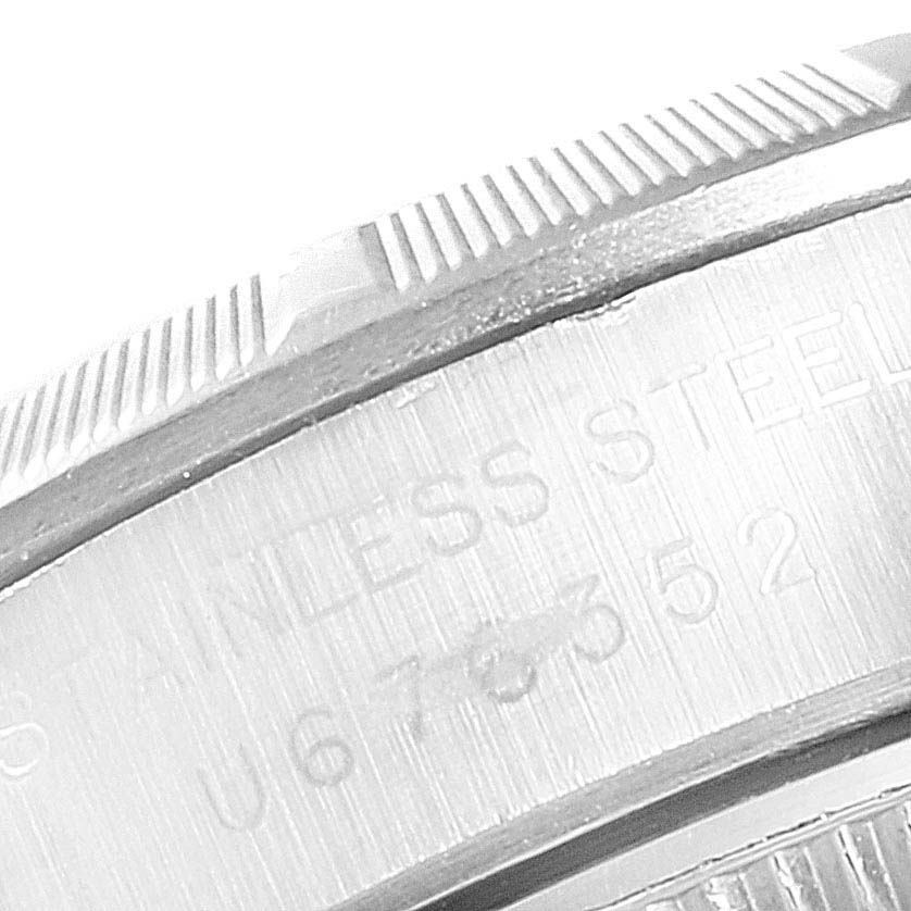 The image shows a close-up angle of the stainless steel bezel and part of the case of a Rolex Oyster Perpetual 67230 Women
s Stainless Steel Blue Dial 67230 Women
s Stainless Steel Blue Dial watch.