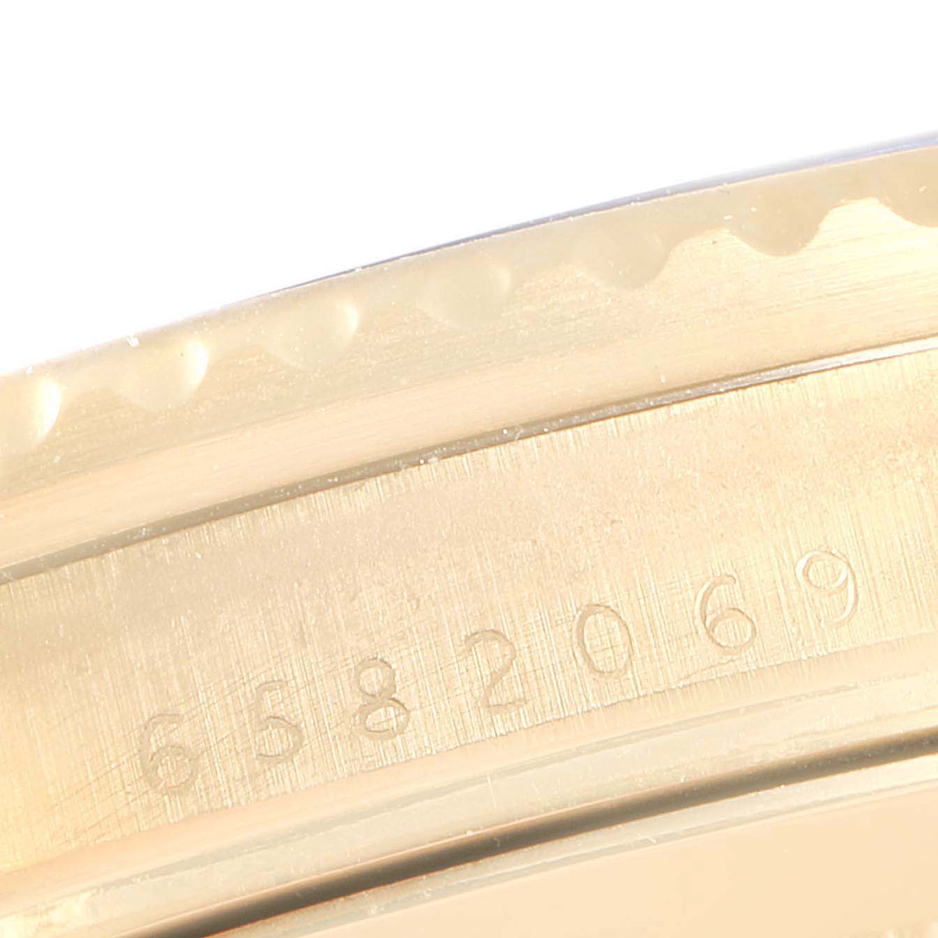The image shows a close-up of the case back edge and serial number of a Rolex Submariner 16808 Men
s Yellow Gold Blue Dial 16808 Men
s Yellow Gold Blue Dial watch.