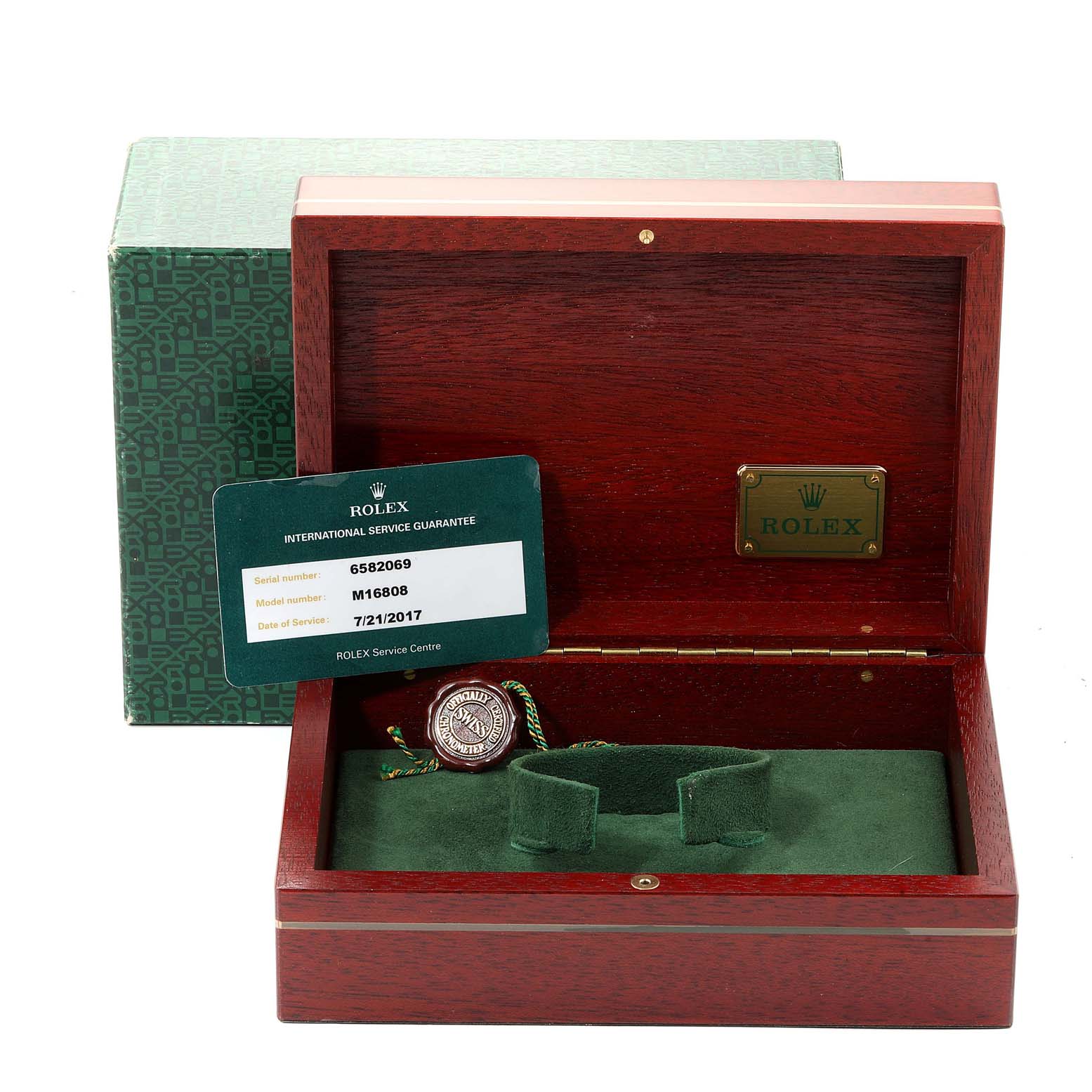 This image shows an open Rolex Submariner 16808 Men
s Yellow Gold Blue Dial 16808 Men
s Yellow Gold Blue Dial watch box, the inner cushion, and an international service guarantee card.